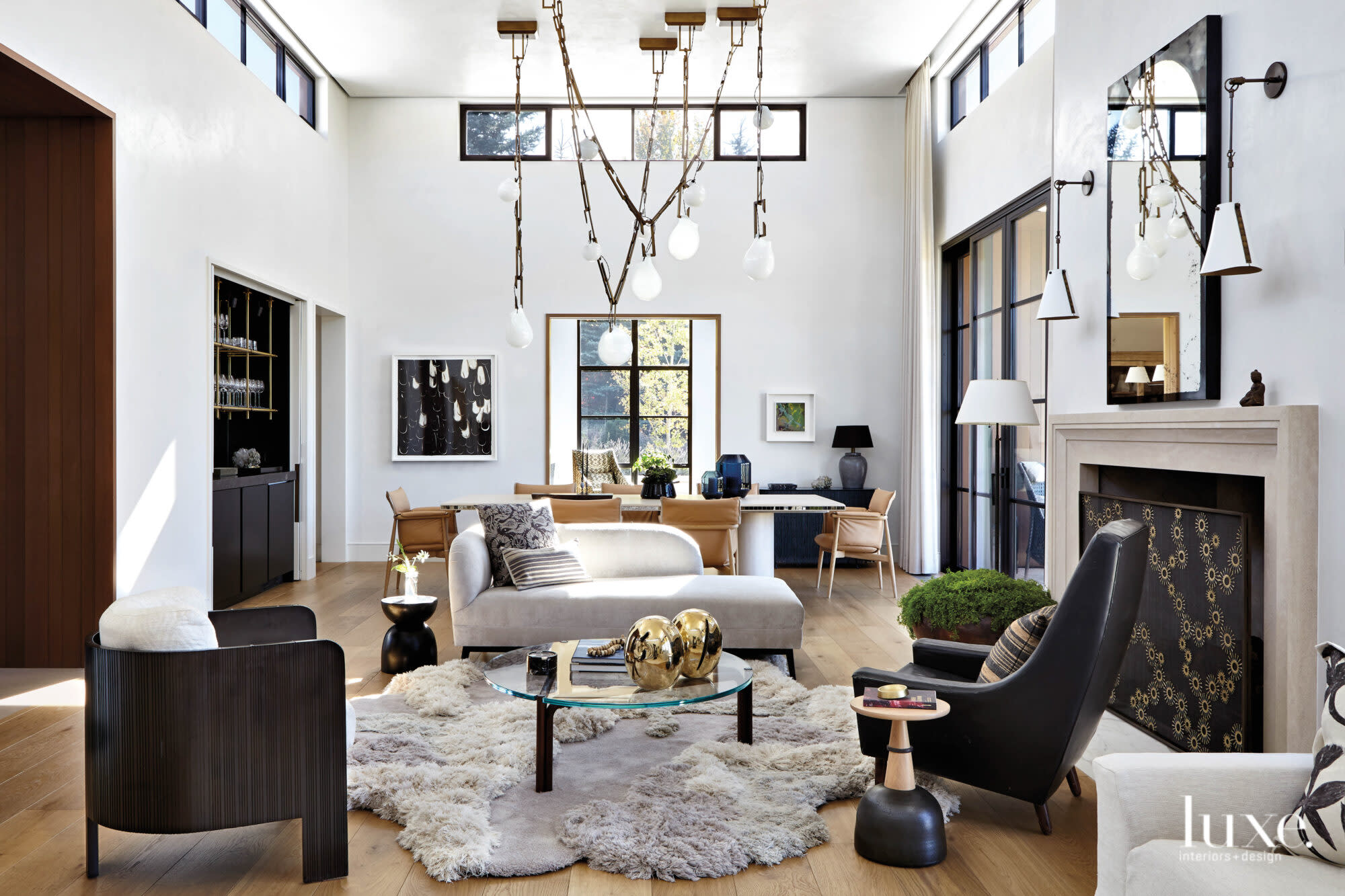 The combined living room and dining room features sculptural furniture and sculptural light fixtures.