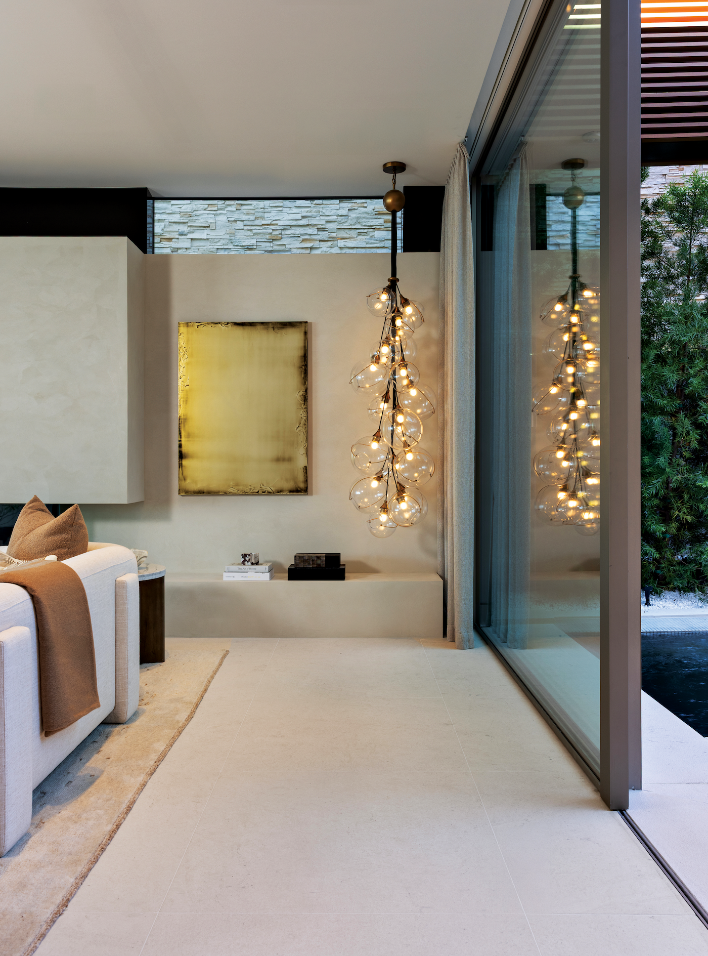 Dining and living area featuring sculptural chandeliers and contemporary artwork.