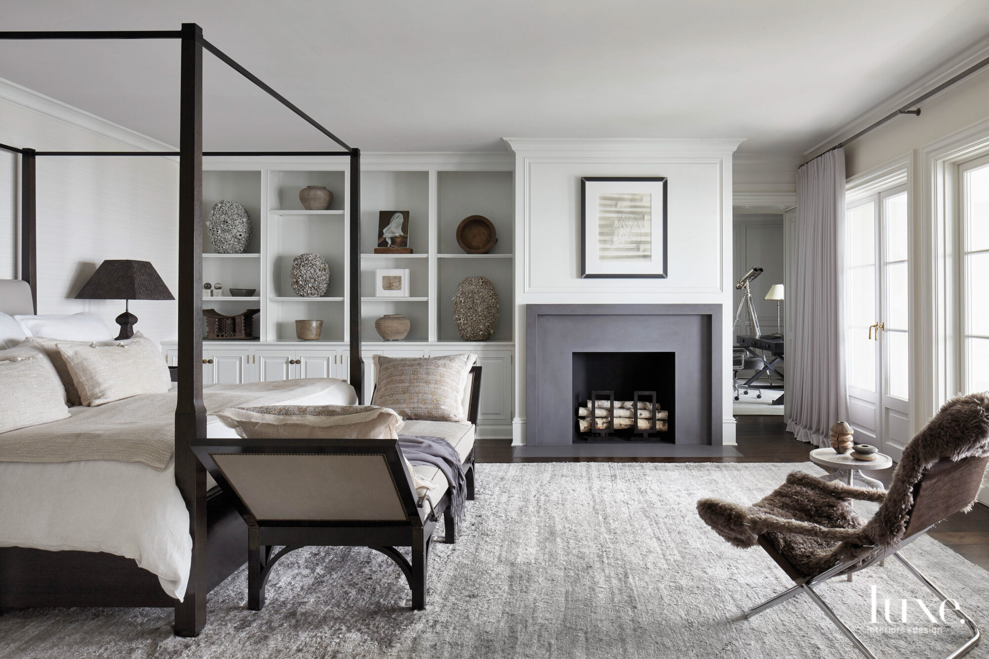 white and gray master zen bedroom with four-poster bed and limestone fireplace