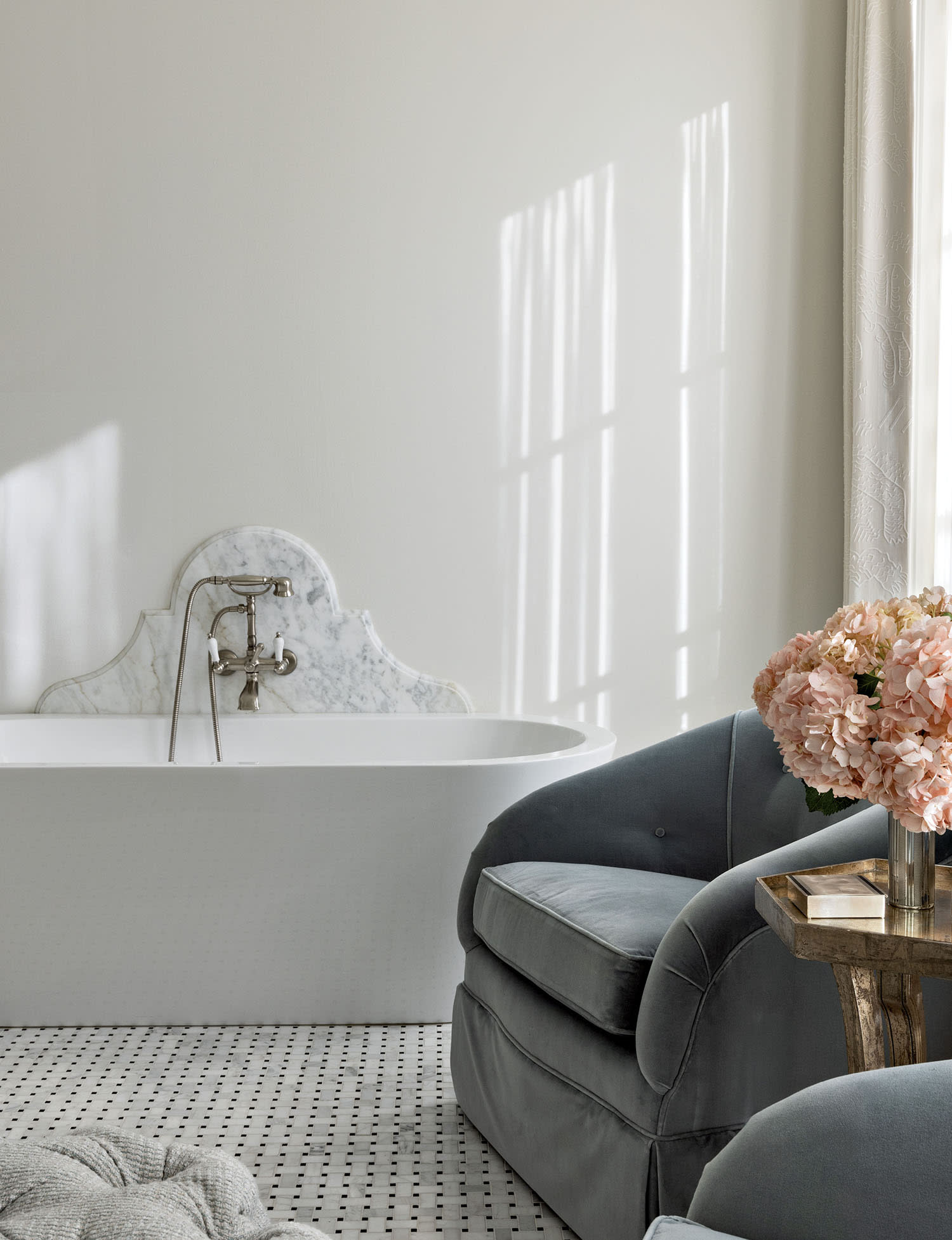 luxurious bathroom featuring a pair of cotton-velvet barrel-back chairs next to the tub
