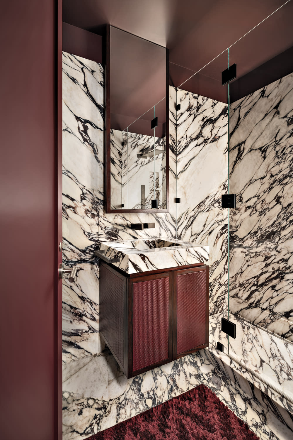 bathroom with Calacatta Viola marble slabs and red accents