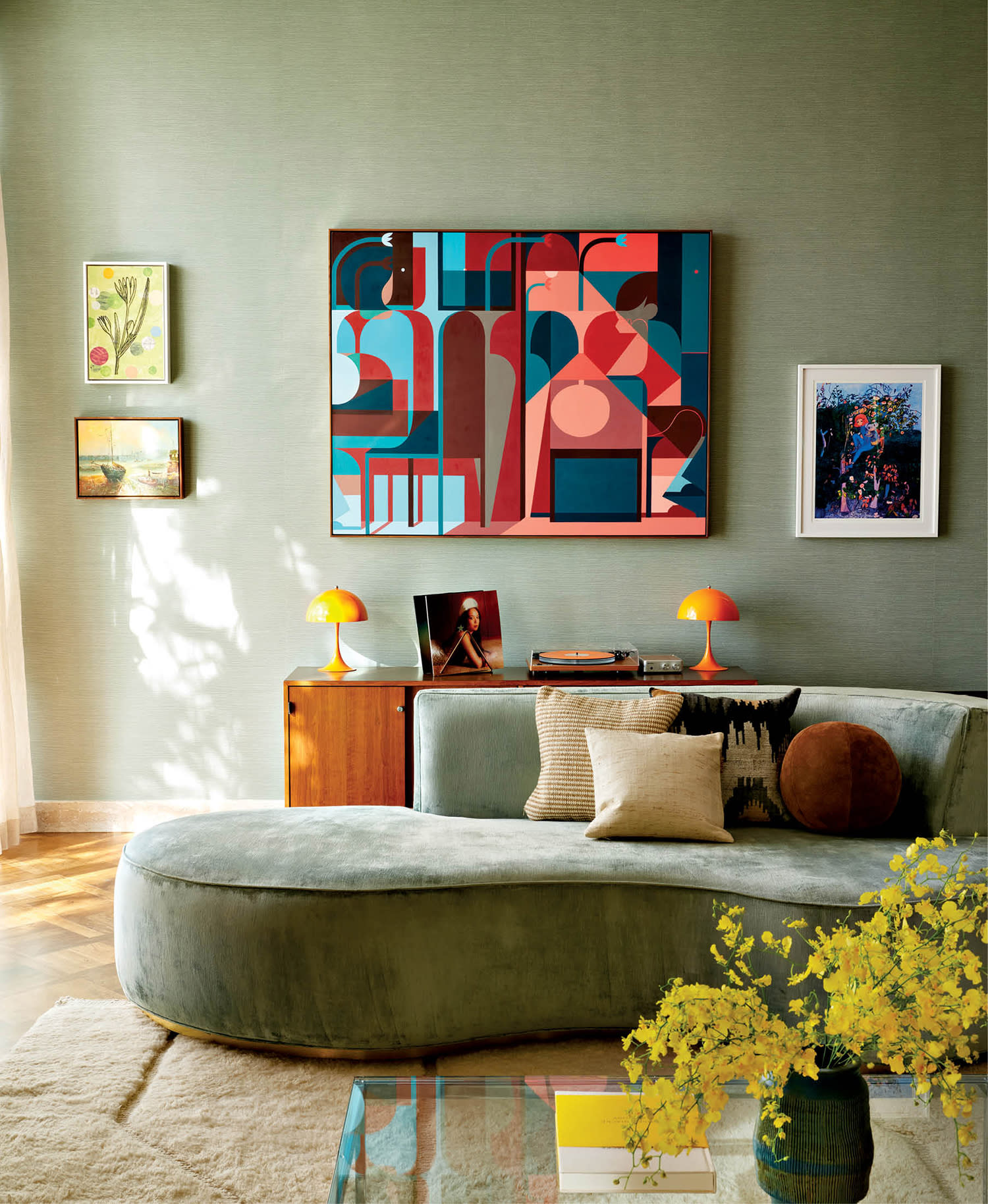 curving sofa in a midcentury modern living room with vibrant artwork on the wall