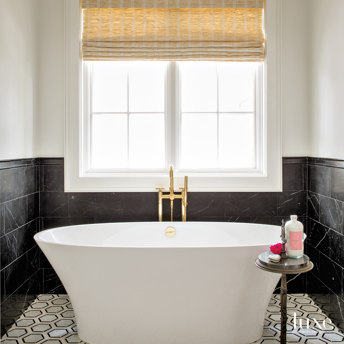 master bathroom with freestanding tub, brass faucet and marble tile flooring