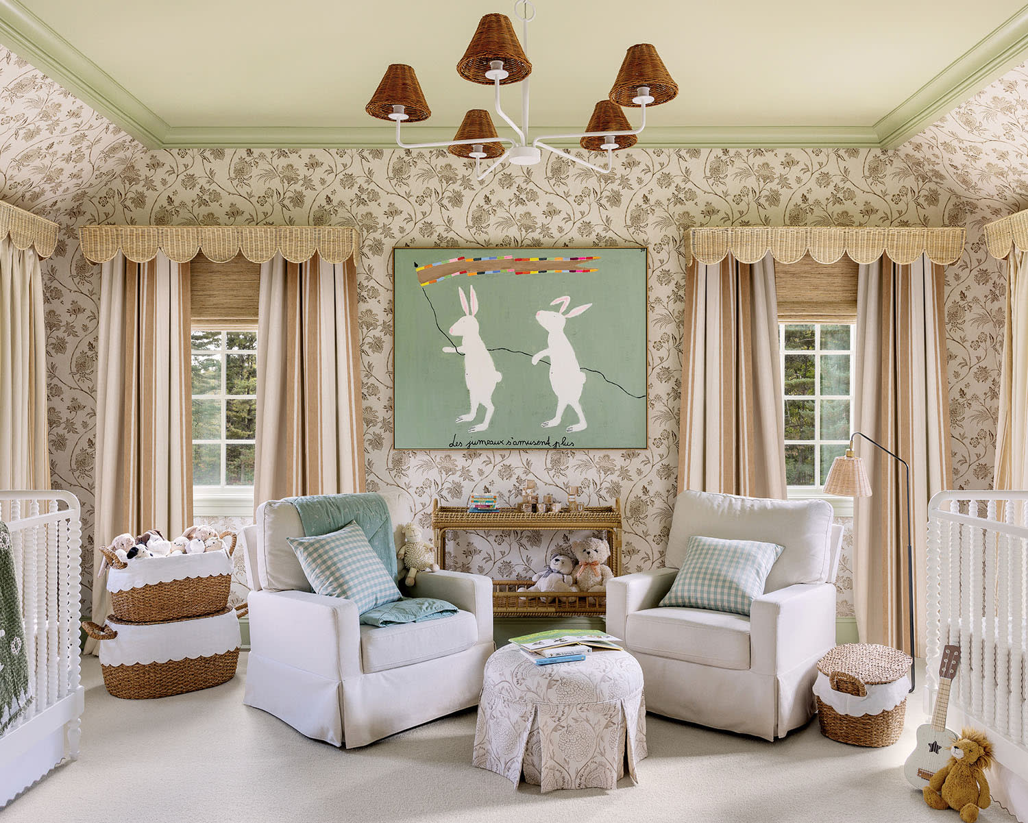 Charming nursery with floral wallpaper, two white cribs, cozy armchairs, wicker baskets, and playful bunny artwork. Light, airy, and whimsical.
