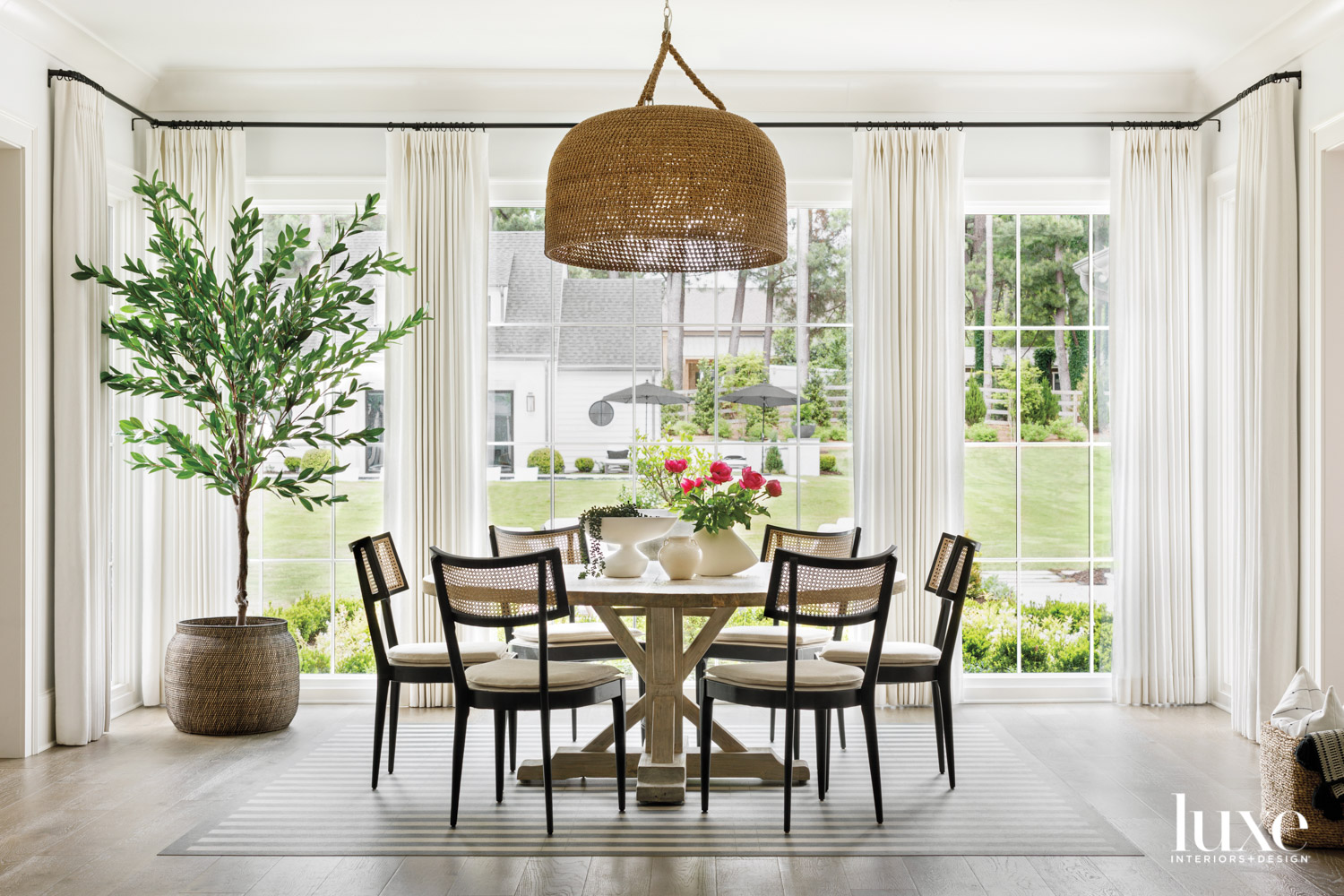 Round table surrounded by chairs in front of large windows