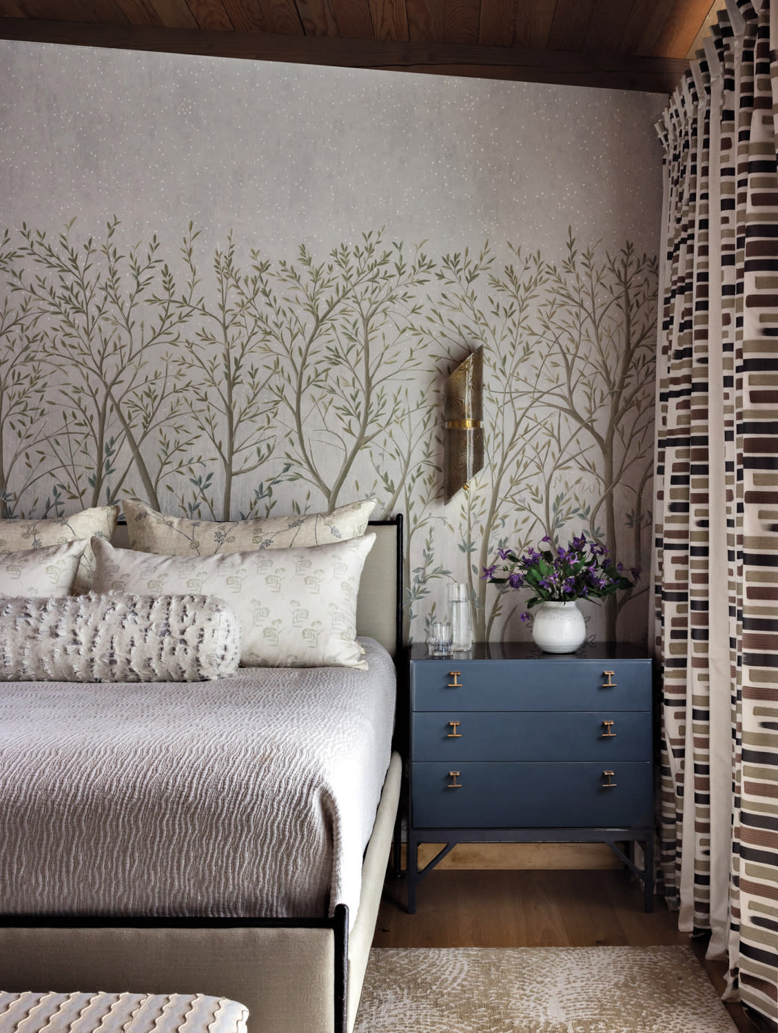 bedroom with a forest-like wallcovering 