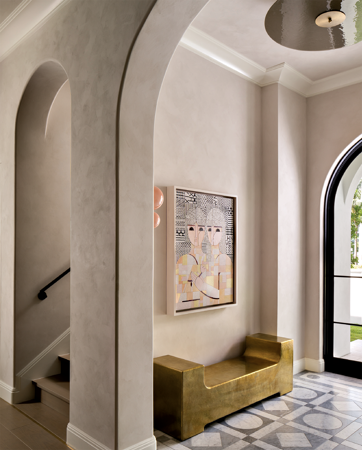 arched doorways lead to a modern entryway with marble-inlay flooring