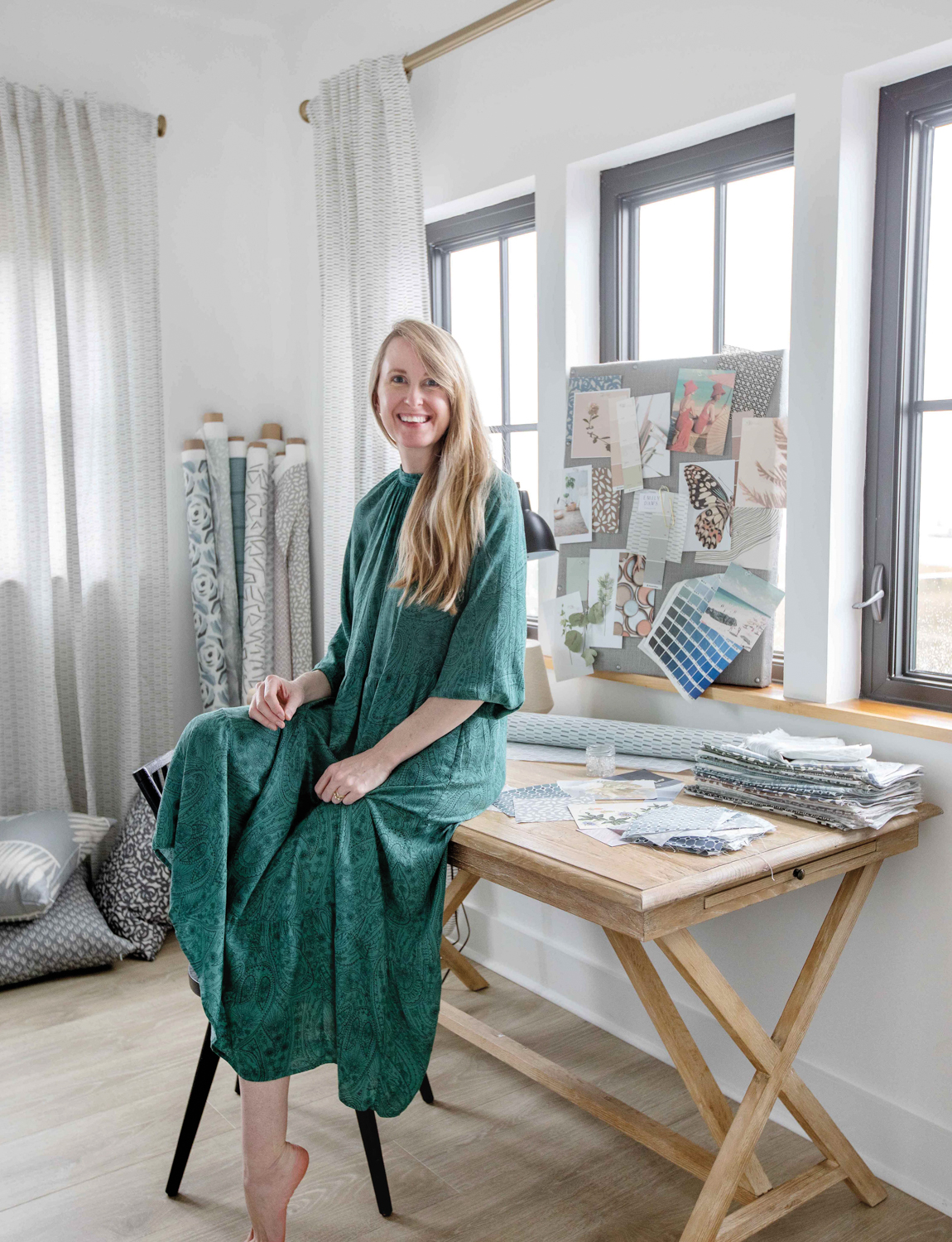 Woman sitting on desk with fabric samples 