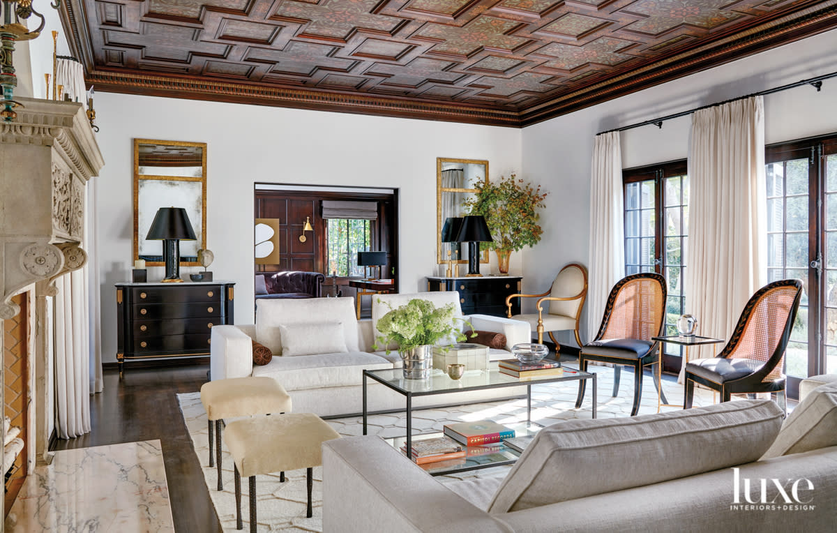 Living room with coffered ceilings and two couches and elaborate fireplace