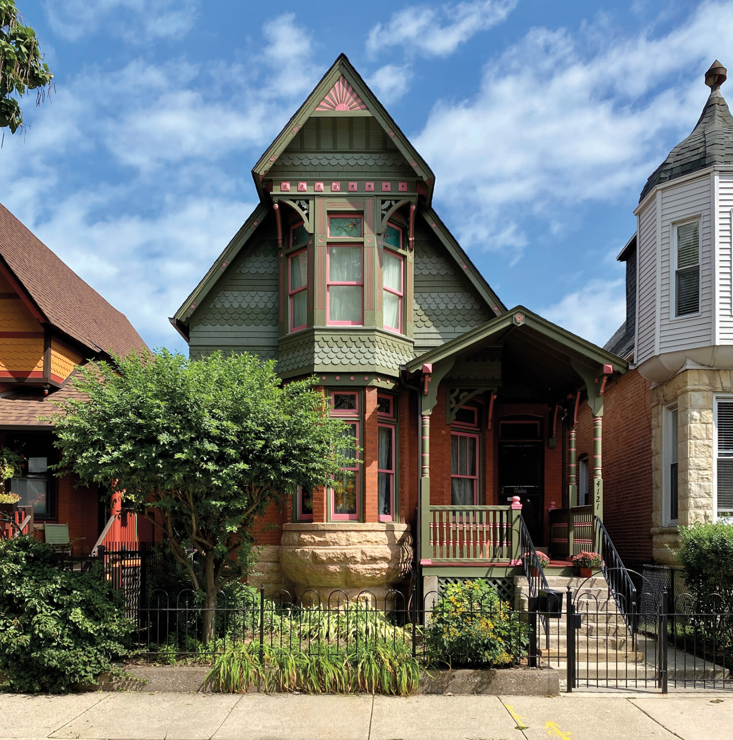 front of jewel tone Chicago two-flat house with front porch and black gate