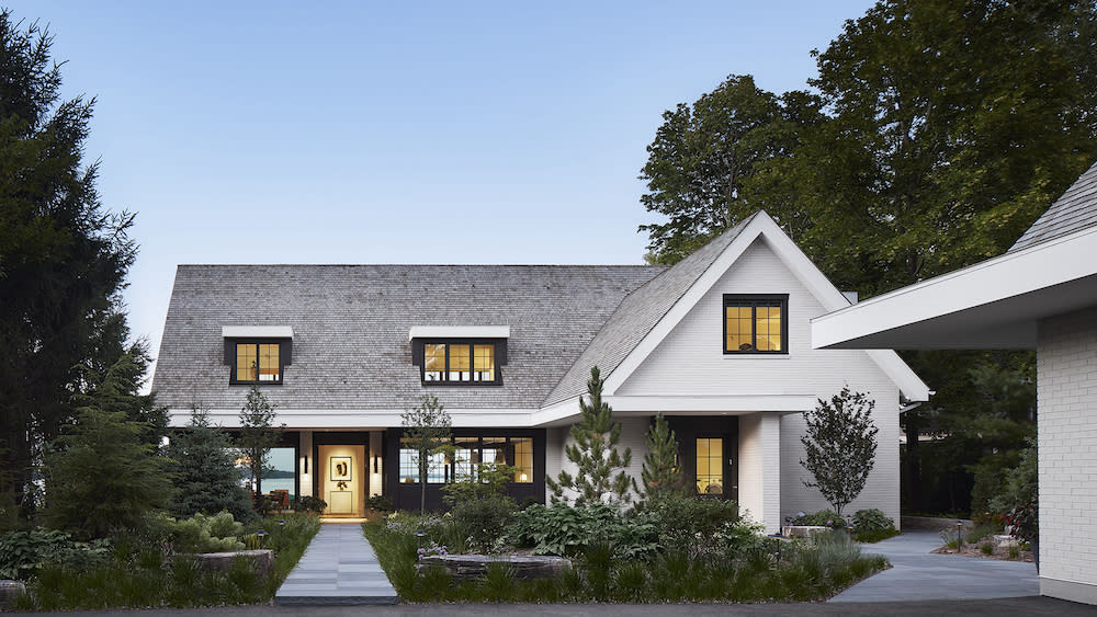 White brick home with contrasting black framed windows and doors