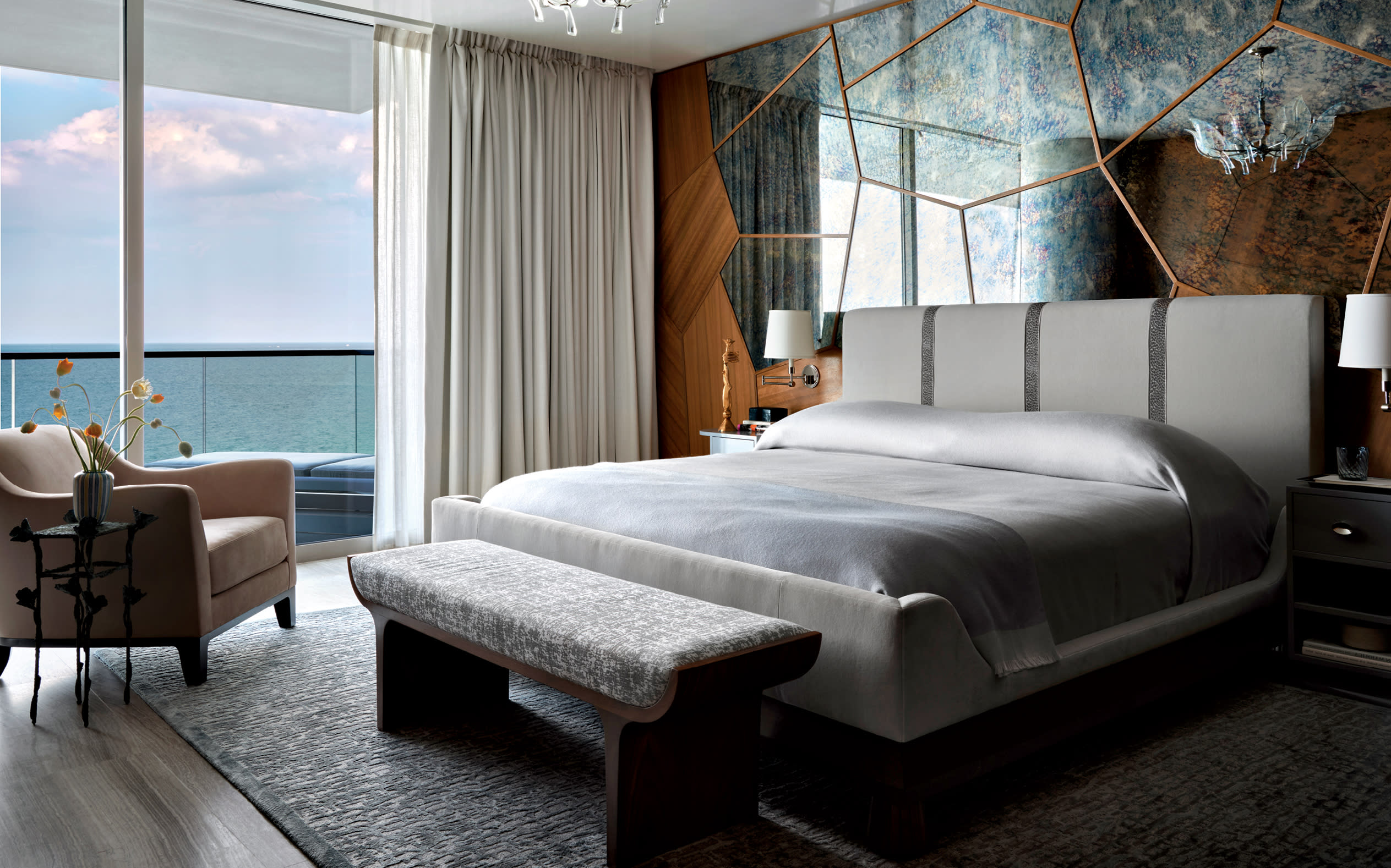 modern bedroom with a mirror and walnut headboard wall and ocean views