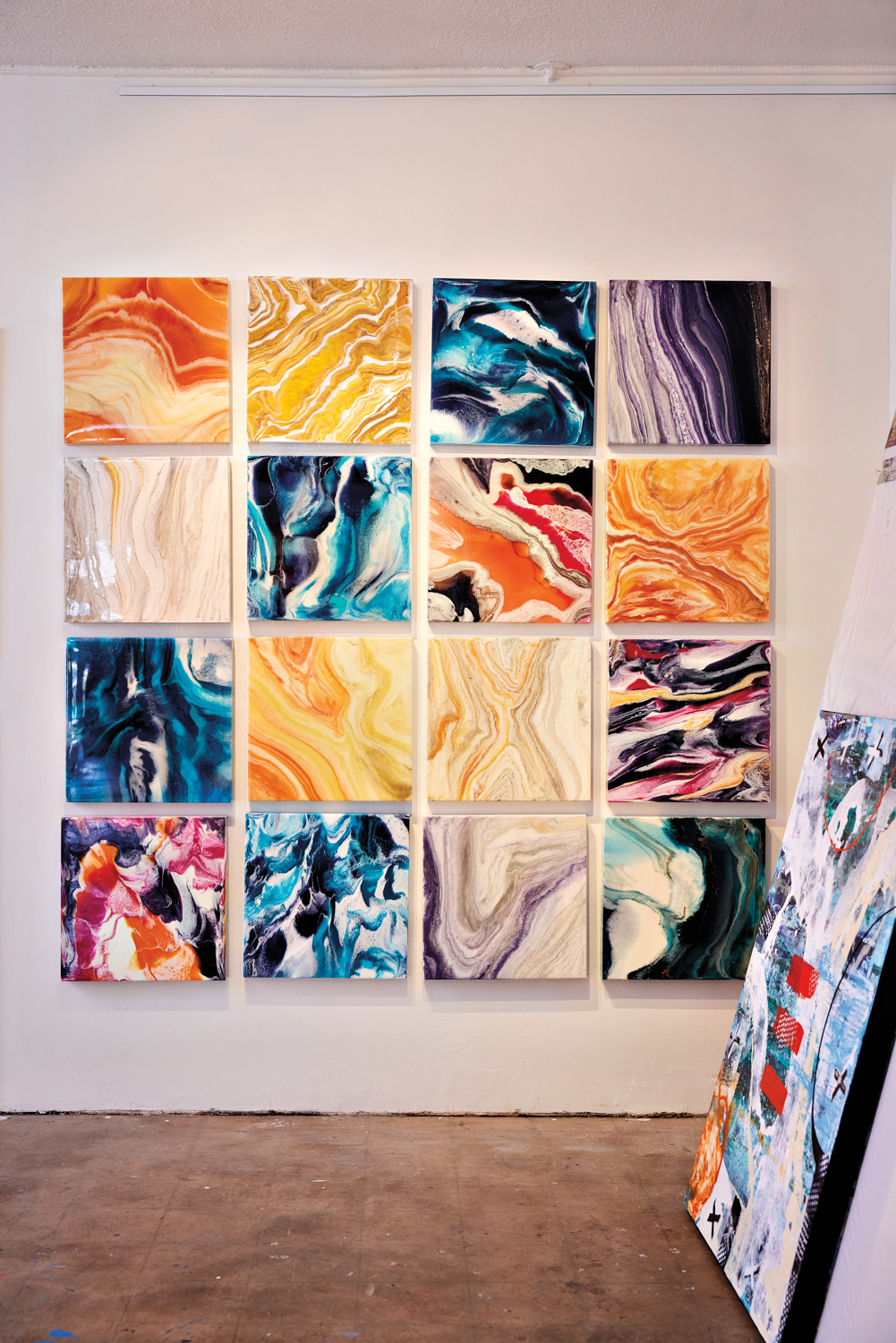 a grid installation of 16 abstract, colorful paintings