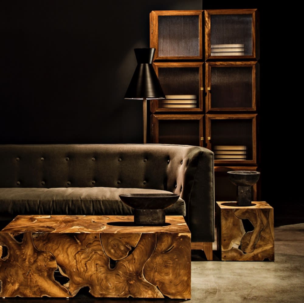 A well-furnished living room with plush couch, coffee table, and wooden side table.