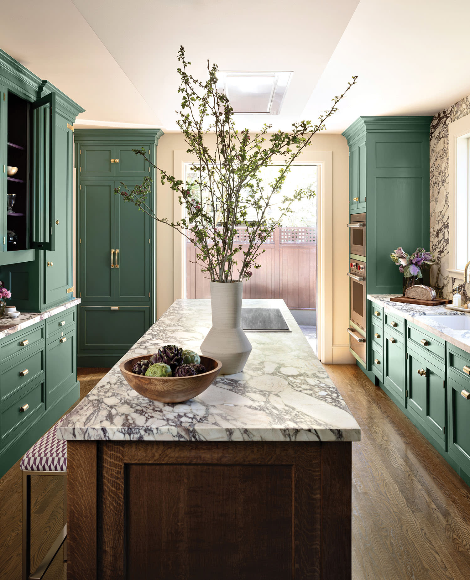 classic kitchen with green cabinetry and a marble-topped island