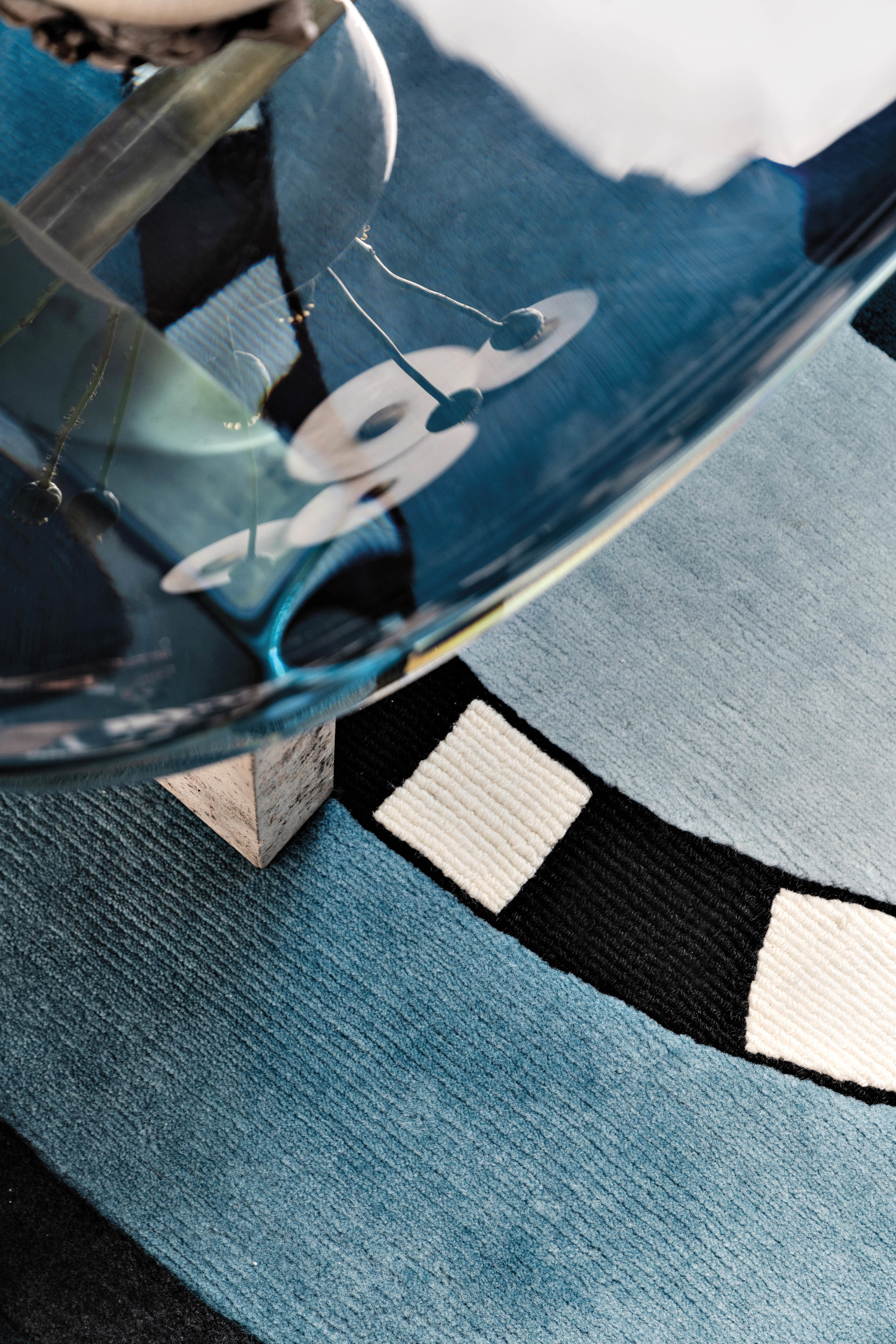 coffee table sitting upon a blue, black and white rug