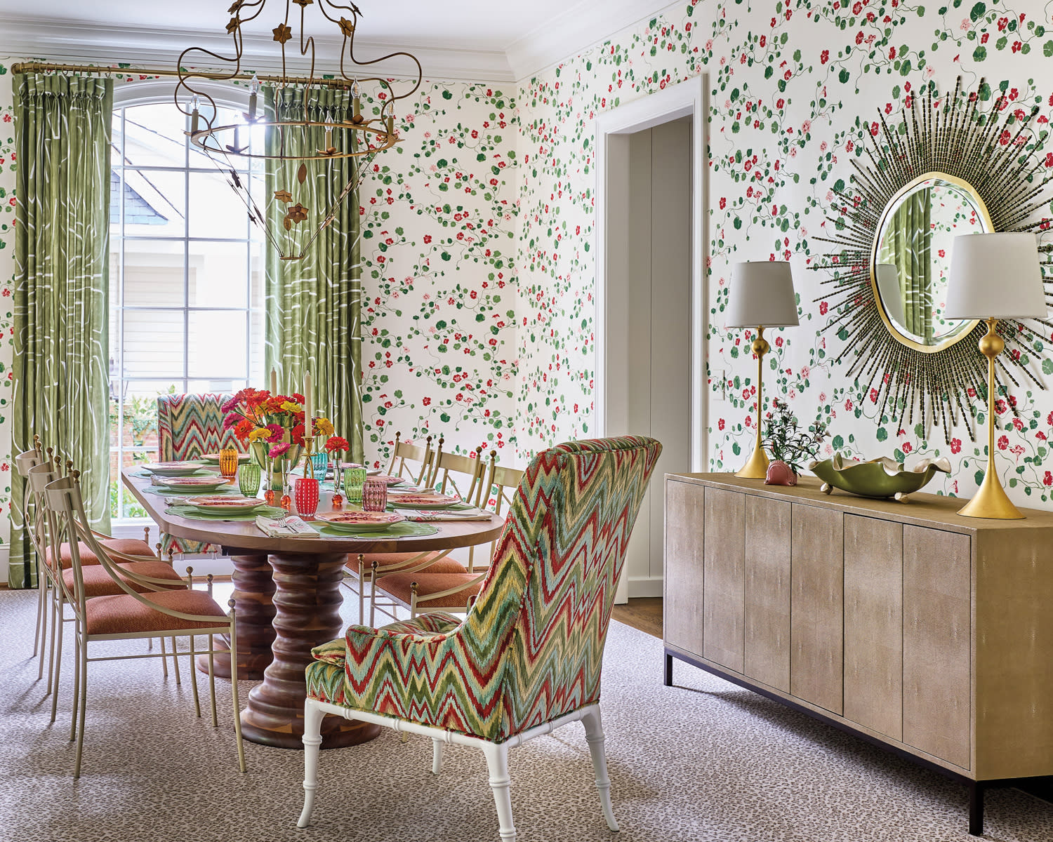 Floral wallpapered dining room with pink and green patterned chairs and drapes