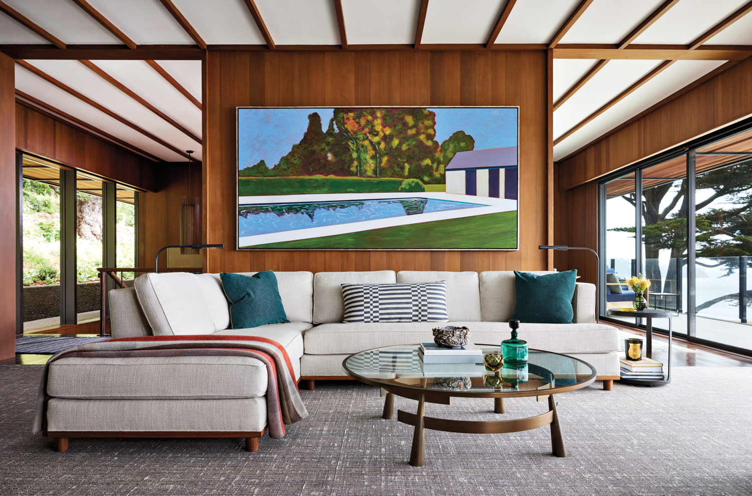 a landscape painting sits above a white sofa in a midcentury living room
