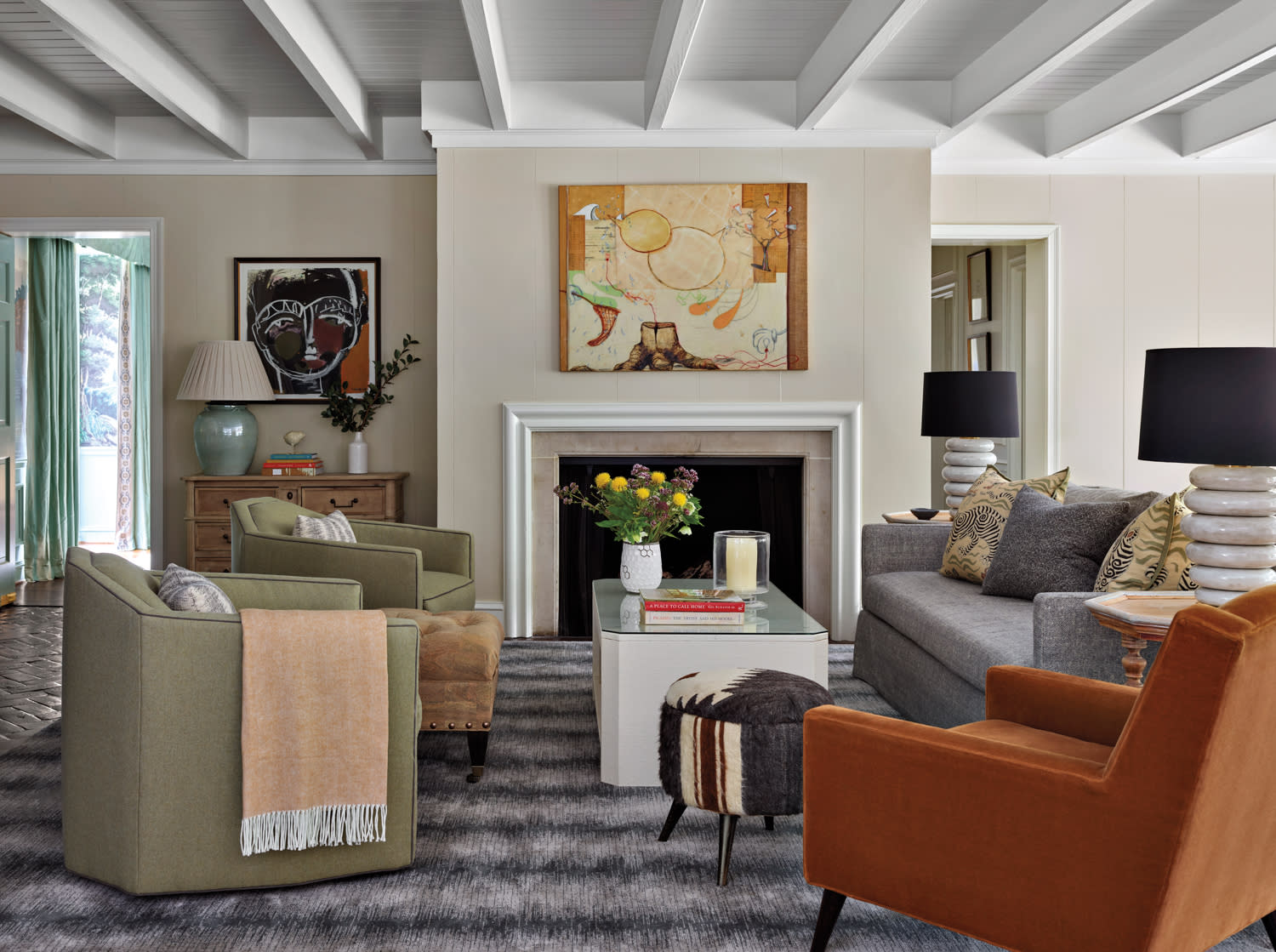 Family room with natural walls, rust accents and an abstracted striped rug