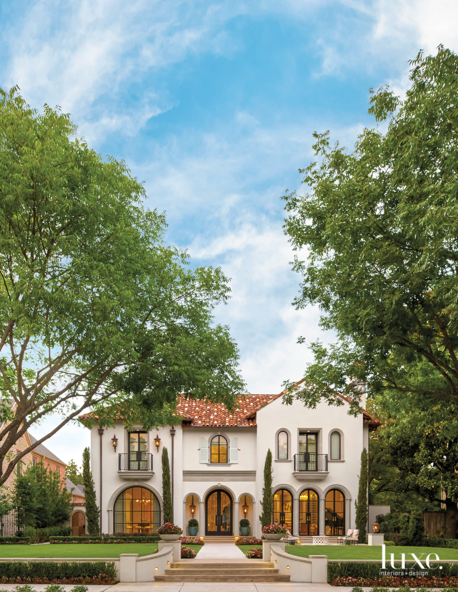 Front facade of a Mediterranean style home with a red clay tile roof.