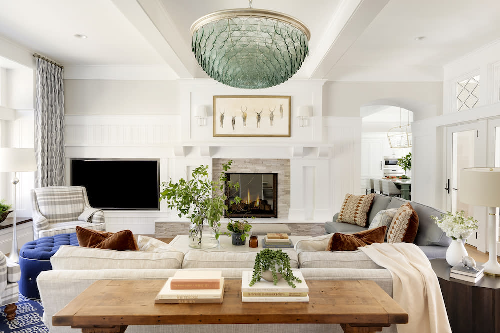 Open concept family room with intricate chandelier and cozy furnishings.