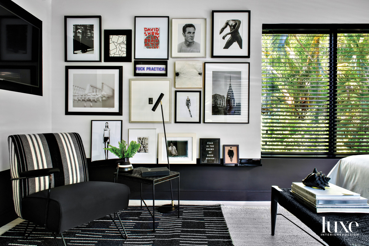 black and white bedroom corner with gallery wall, black chair and black rug