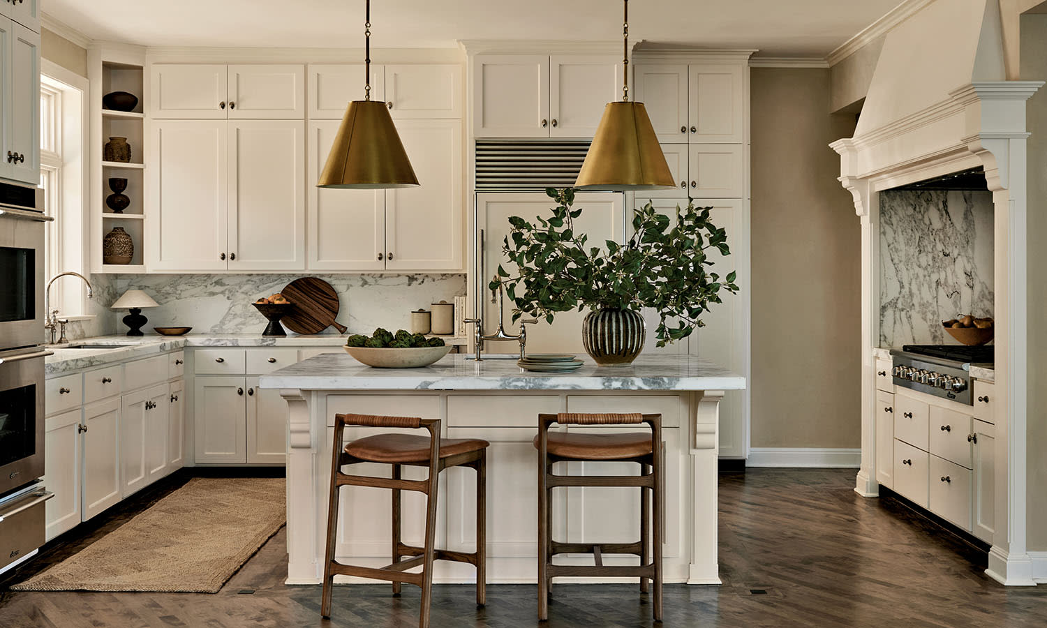 A modern kitchen featuring white cabinets and a stylish gold pendant light hanging above the countertop.