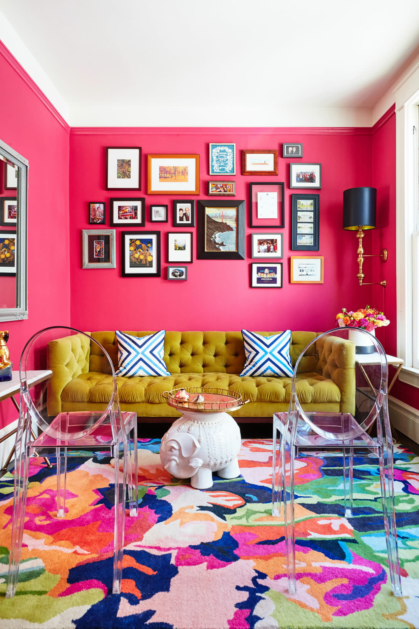 bright pink living room with velvet couch and colorful gallery wall