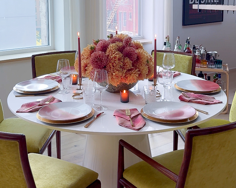 table set with dinner plates, flowers and candles
