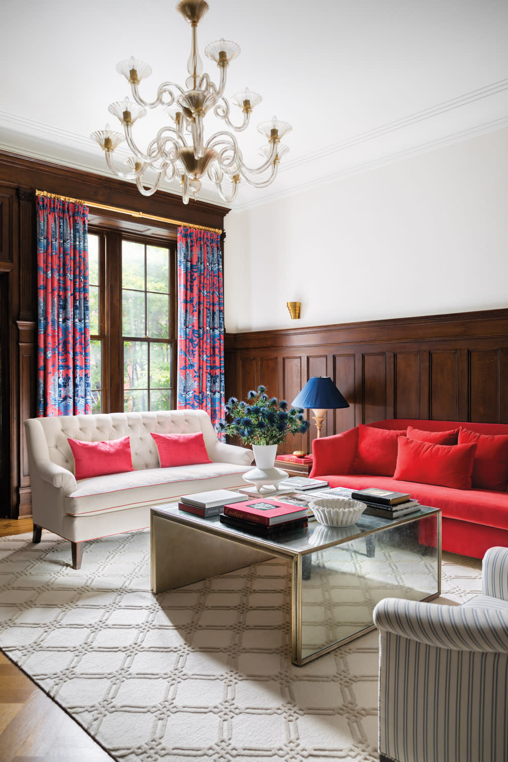 living room with red couch, pink and blue drapes and white sofa