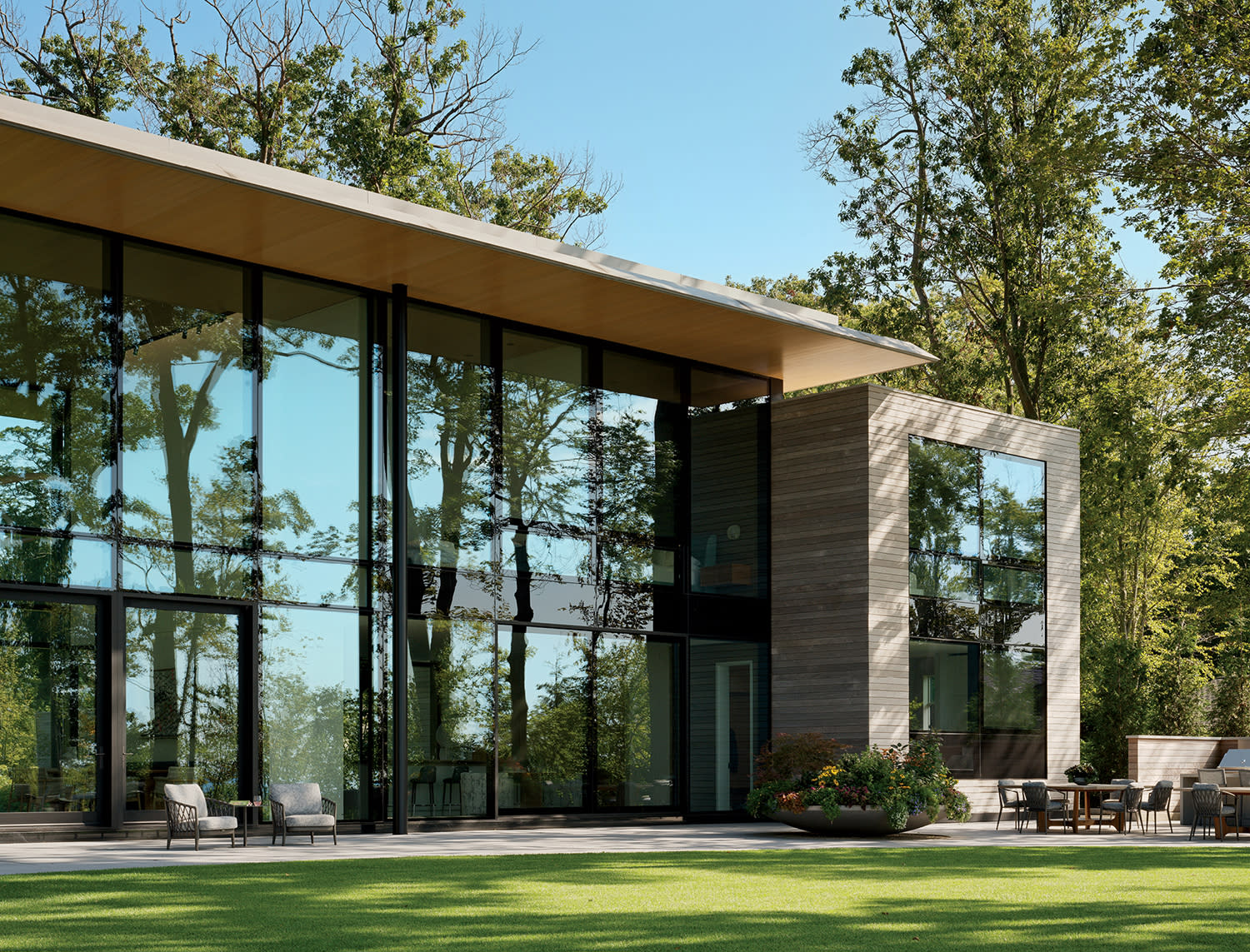 the back exterior of a modern glass-walled home in Michigan