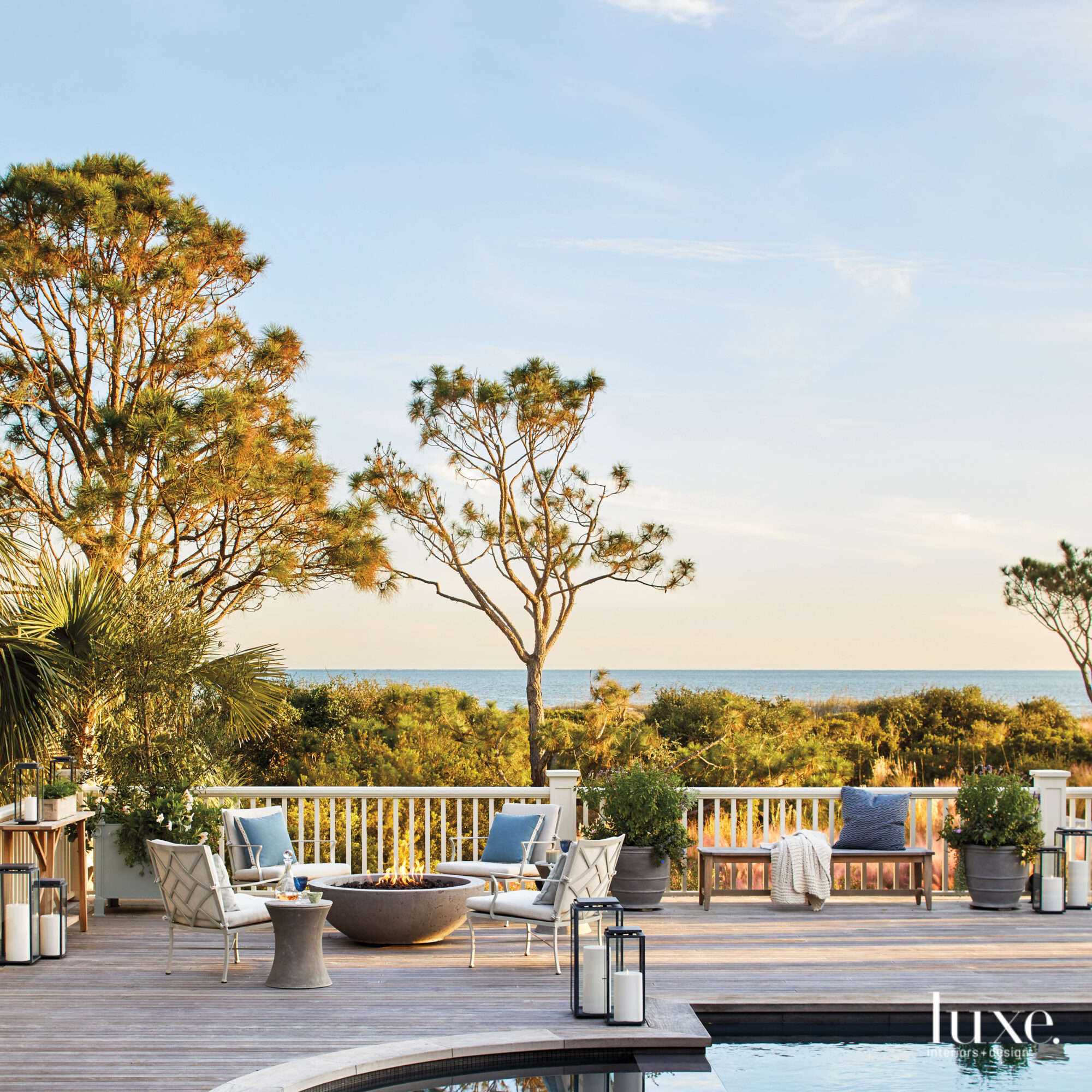 Outdoor furniture gathered around a deck featuring a fire pit and pool