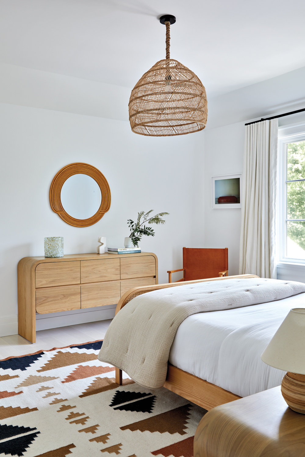 guest bedroom with wood dresser and neutral bed comforter