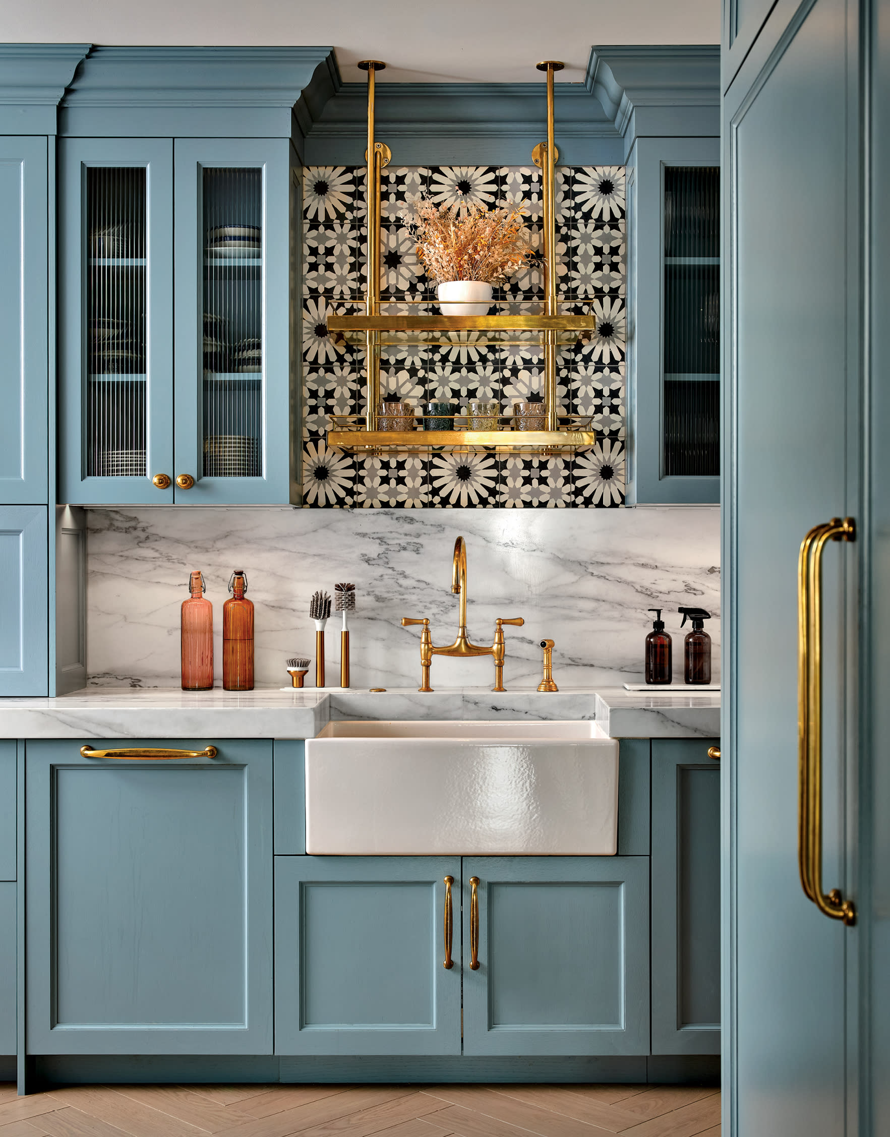 blue kitchen cabinetry mixes with brass fixtures in a vintage charm-inspired kitchen