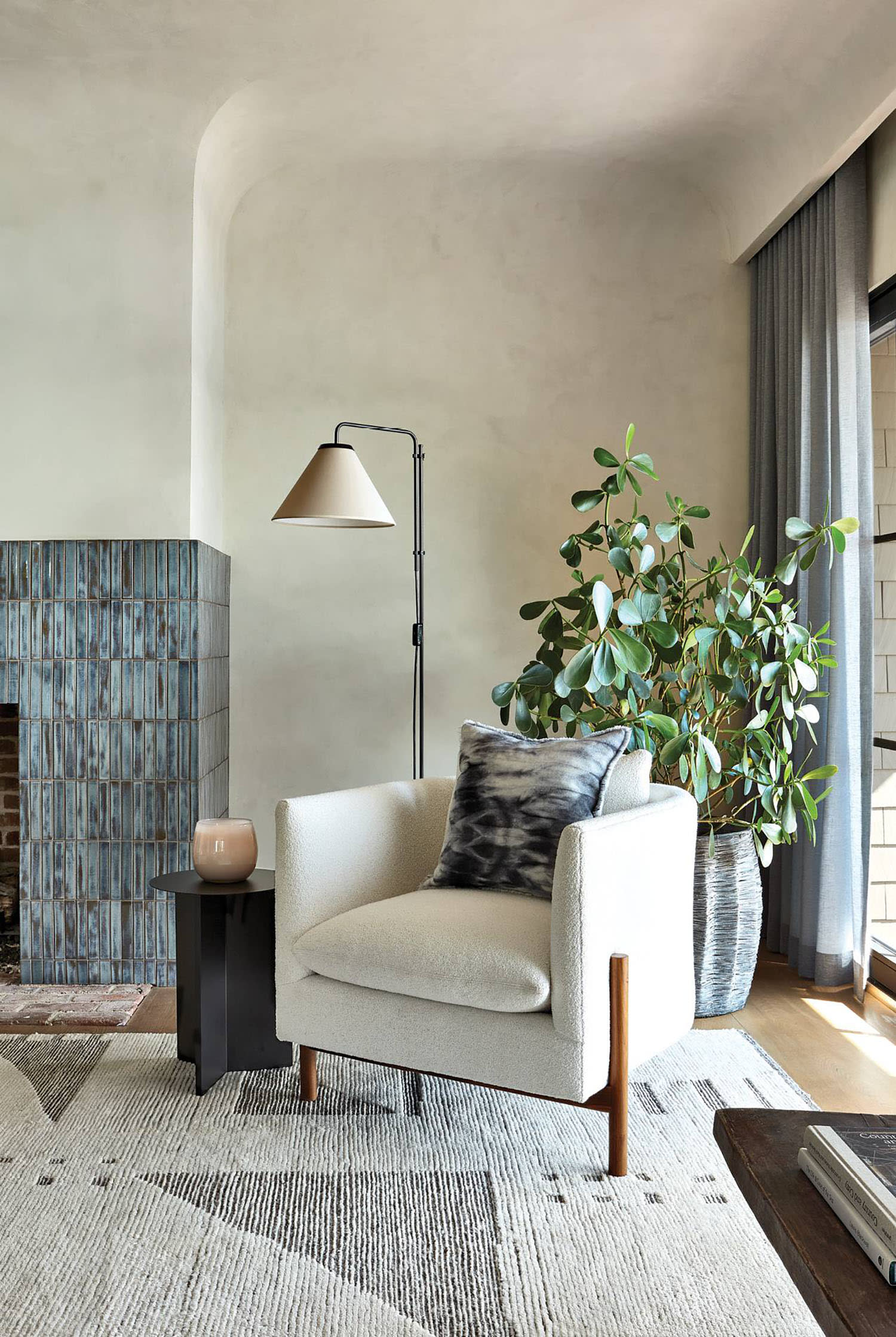a tile surround fireplace next to a Verellen chair makes for a cozy spot in this bedroom