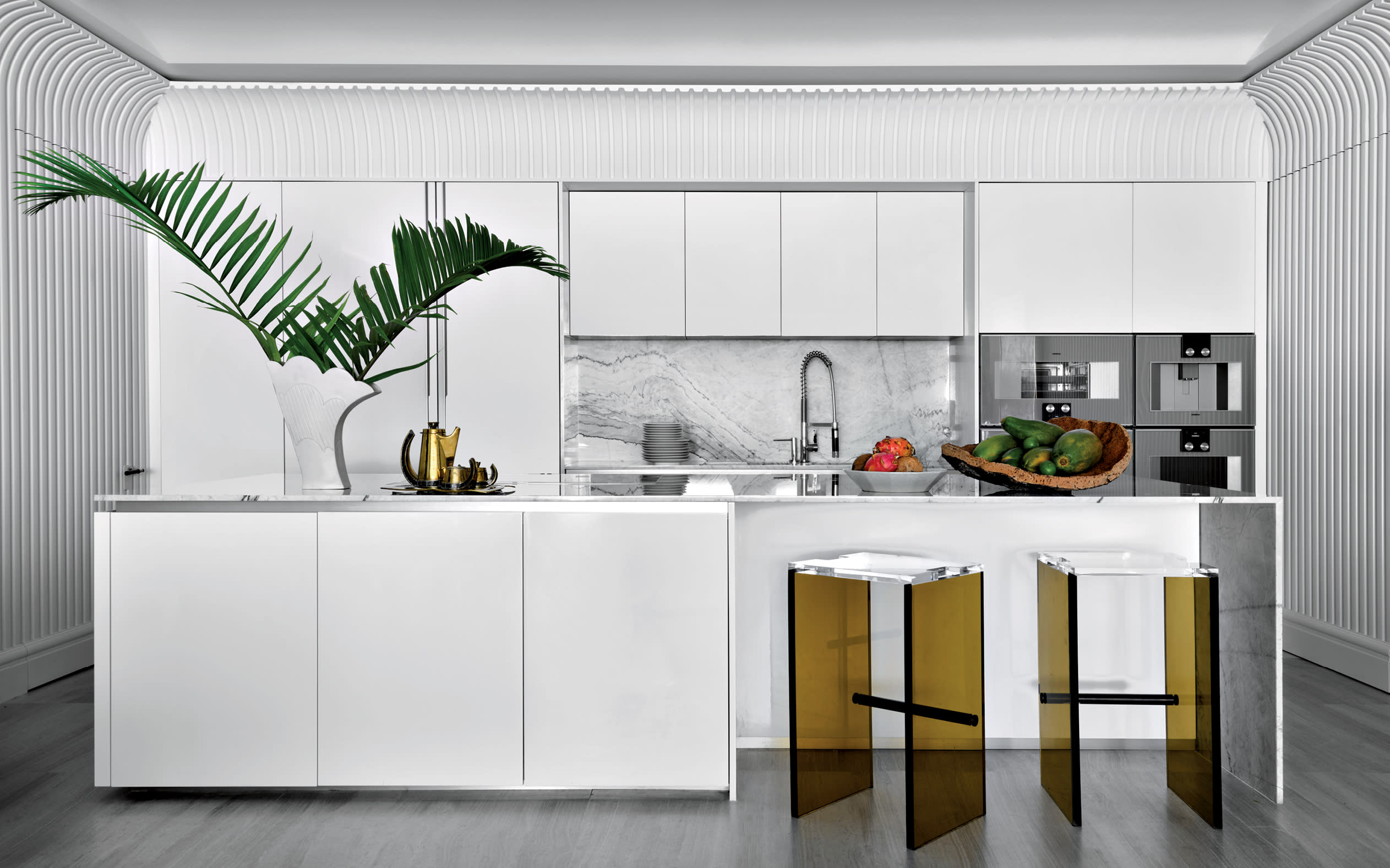 modern white kitchen with transparent barstools and fluted walls