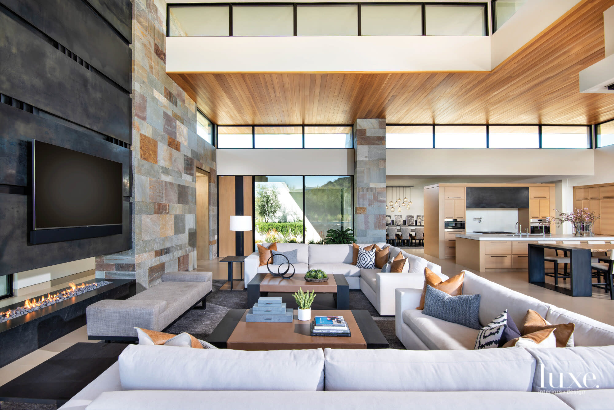 The great room with white sectional sofas and leather-wrapped ottomans.