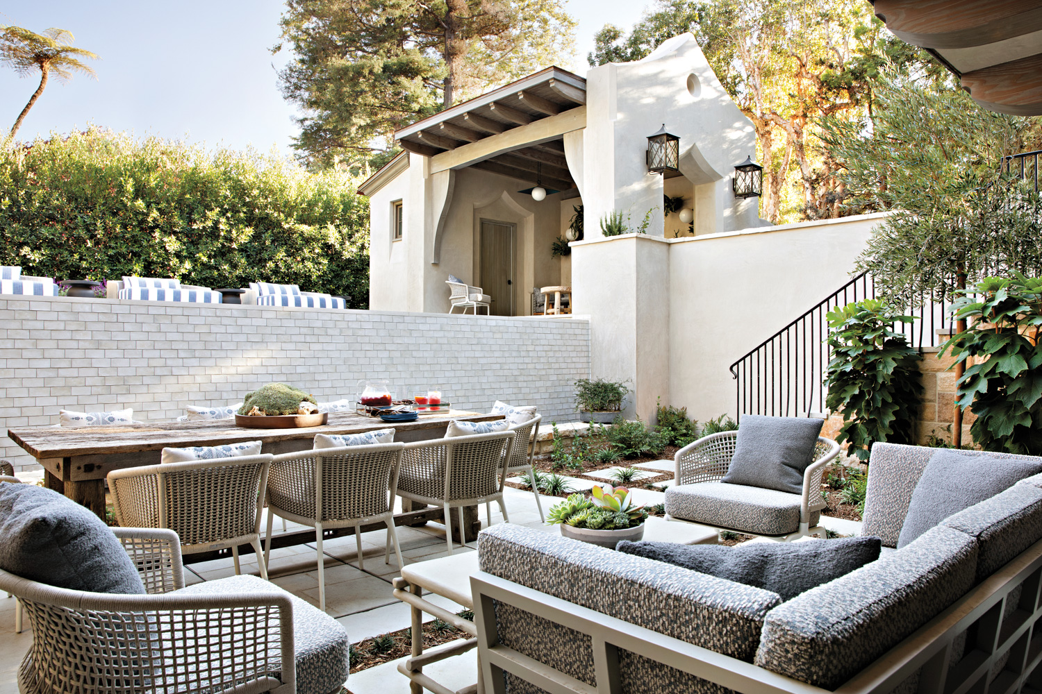 Exterior shot of house with outdoor dining area and conversation area.