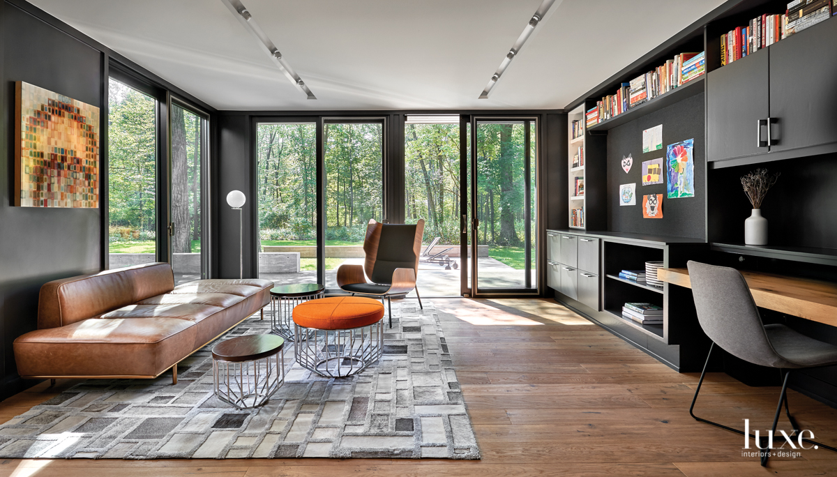 Atop a cowhide-and-bamboo pile rug from Mitchell Gold + Bob Williams, a plush leather lounge sofa from CB2 and an armchair by Gus Modern from Stitch Chicago turn the office into an extension of the family room. Toukoumidis collaborated with consultant Anne Kustner on the lighting design.