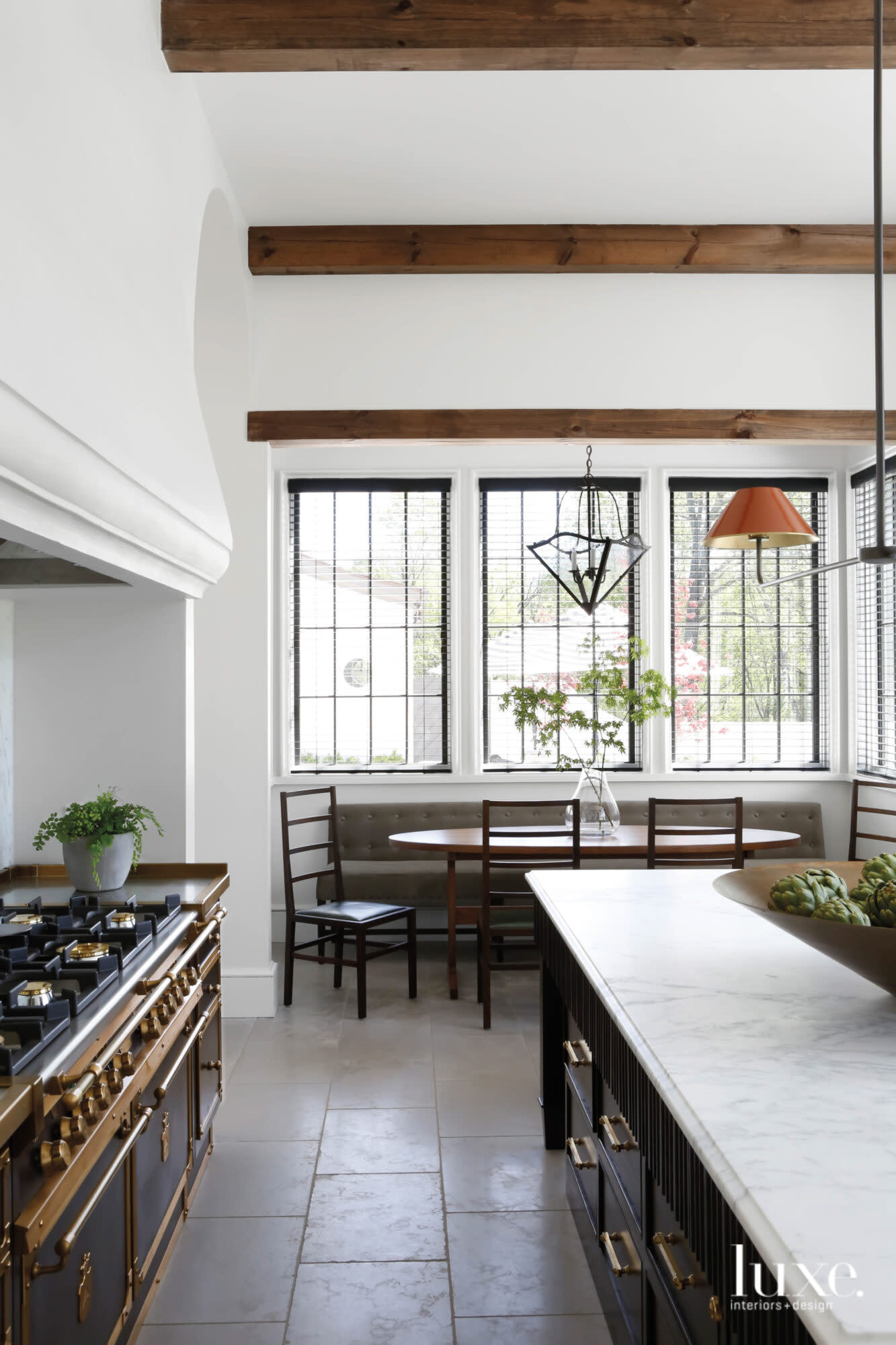 A kitchen featuring limestone floors, a large Island, breakfast table and Office Gullo range