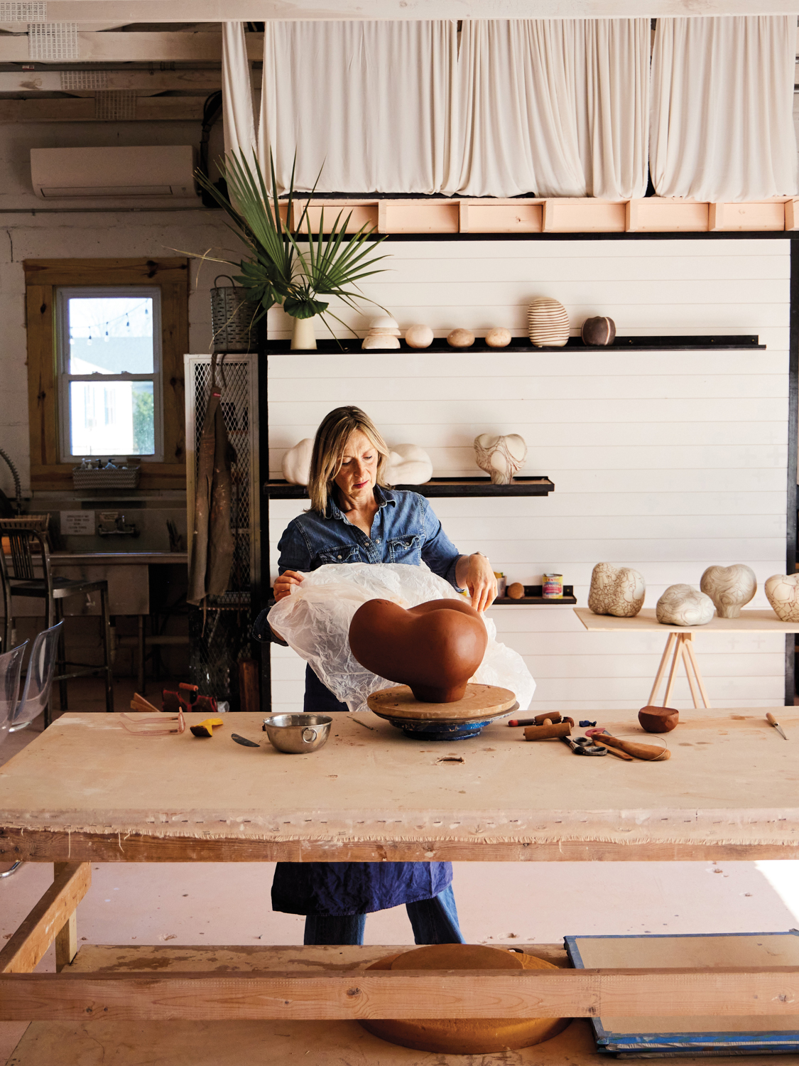 Nadia Stieglitz removing a wrapping from a rounded object