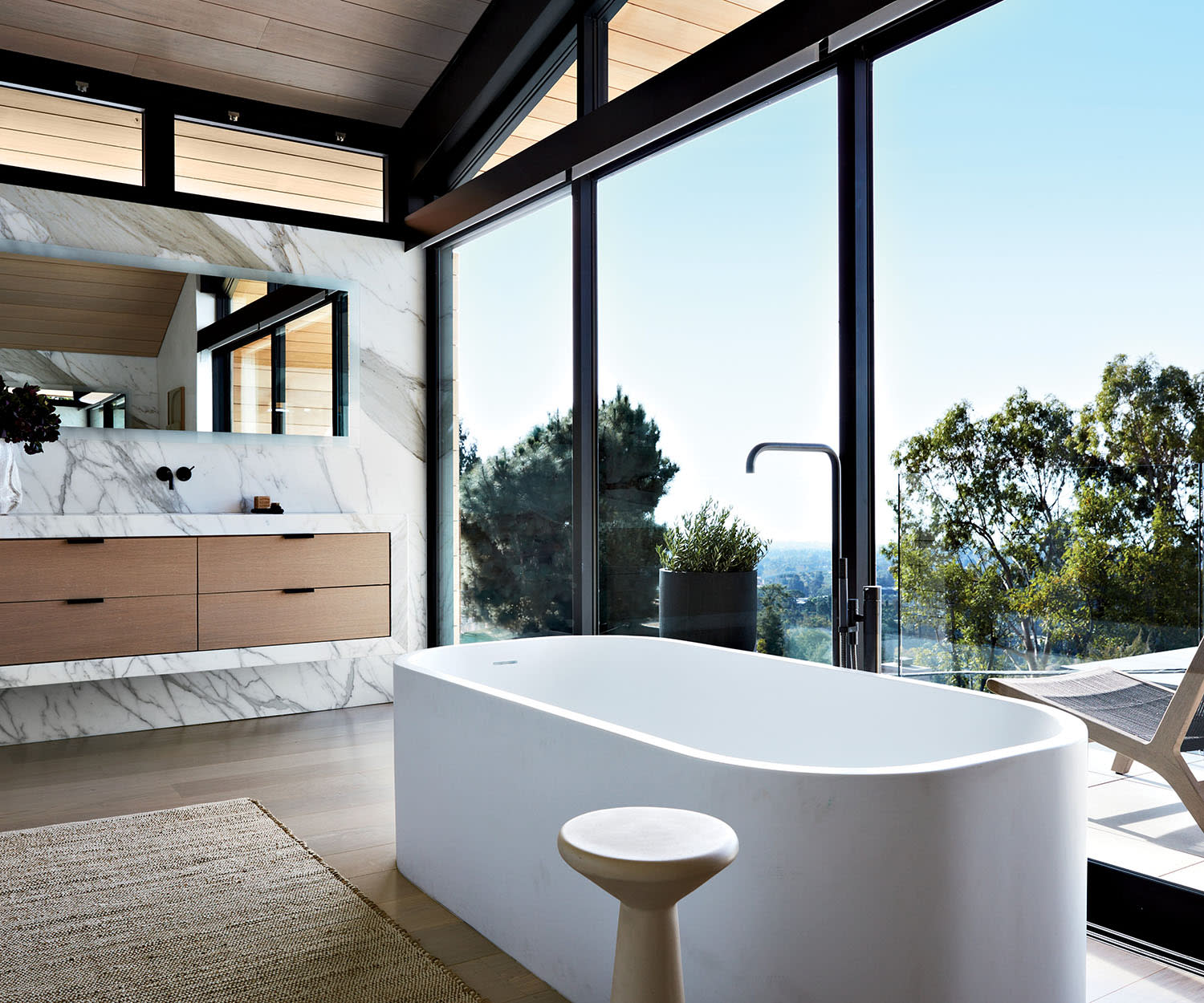modern bathroom with a floating oak vanity and a freestanding tub