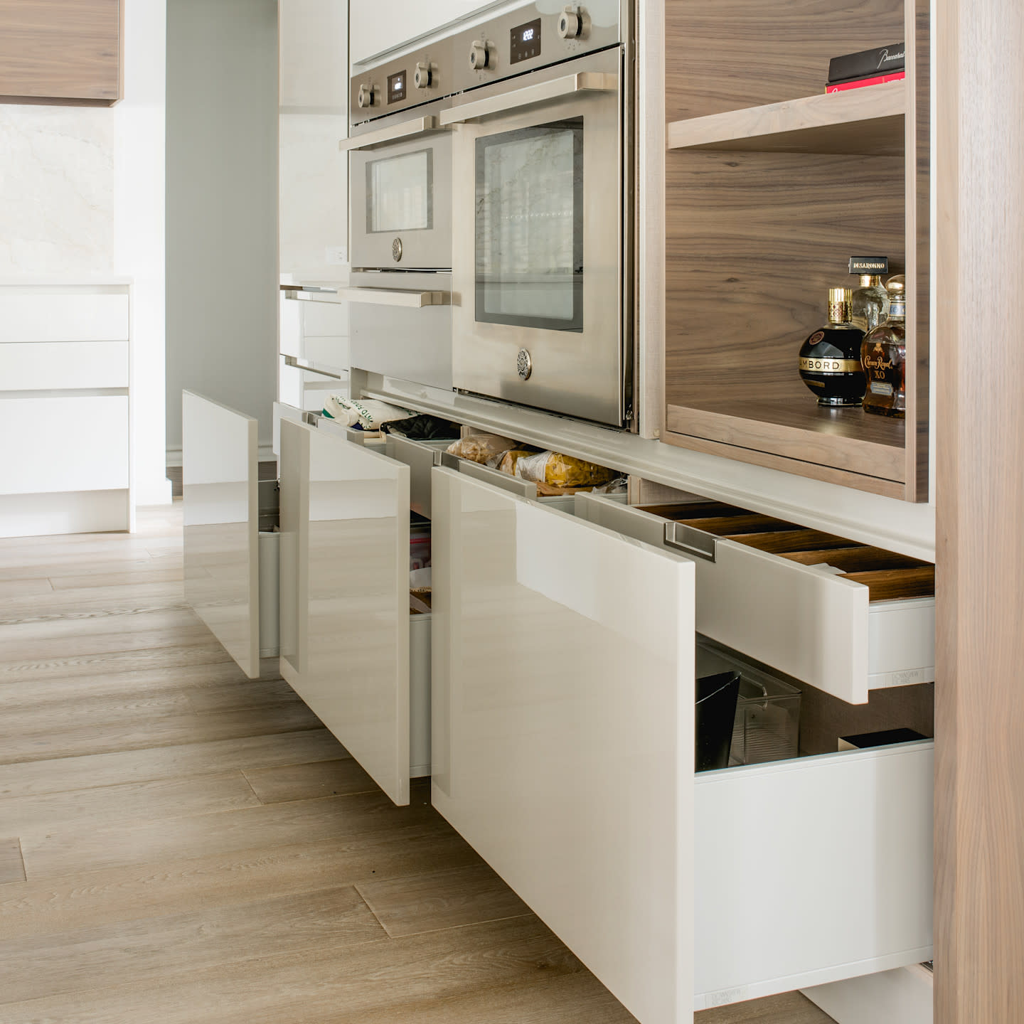 A custom deep drawer reveals thoughtfully designed interior organization, combining warm wood dividers with sleek white cabinetry. Functional elegance meets precision craftsmanship, ensuring everyday essentials are stored with intention, accessibility, and refined simplicity.

Photo by: Costa Christ