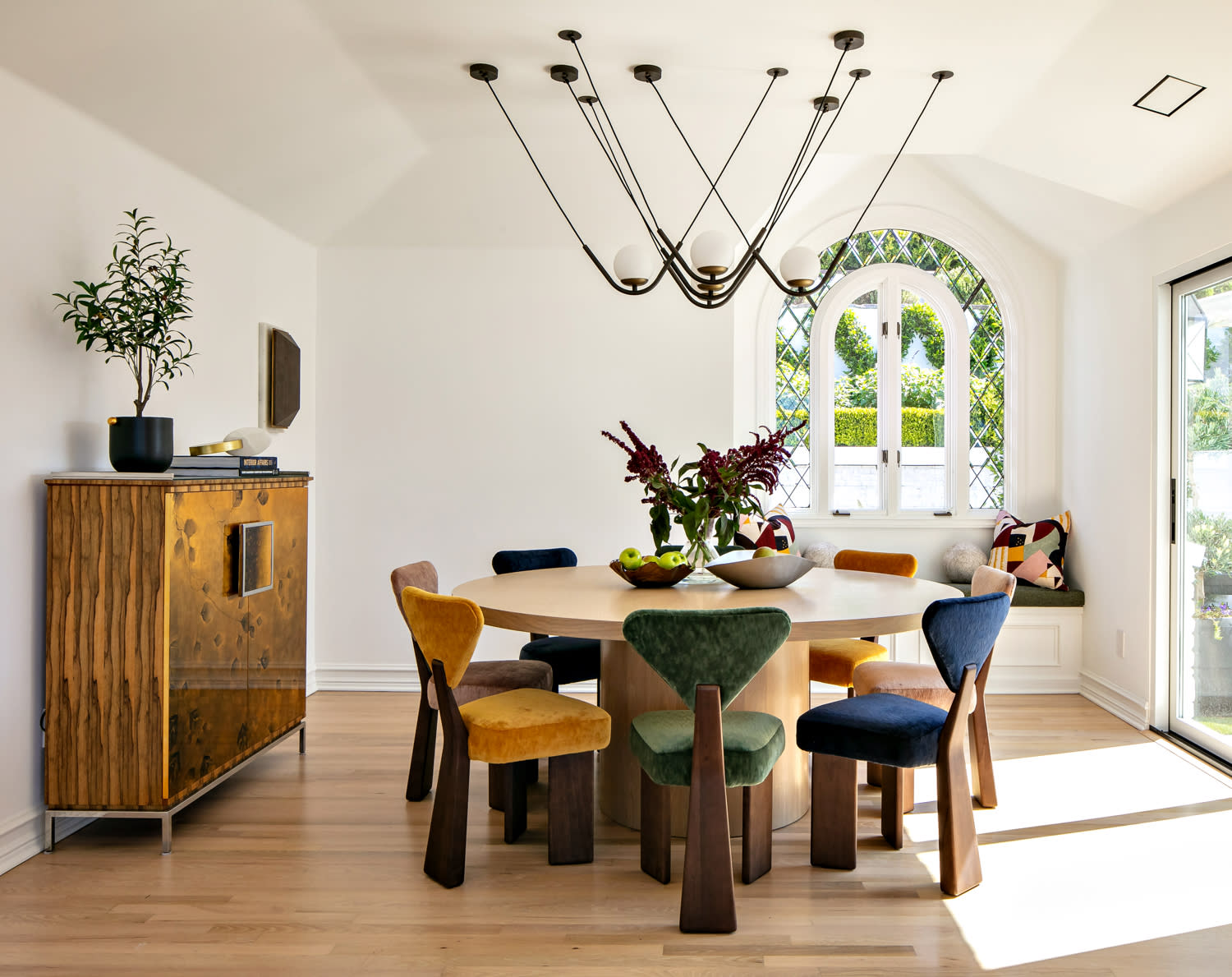 contemporary dining room with chairs upholstered in varying jewel tones