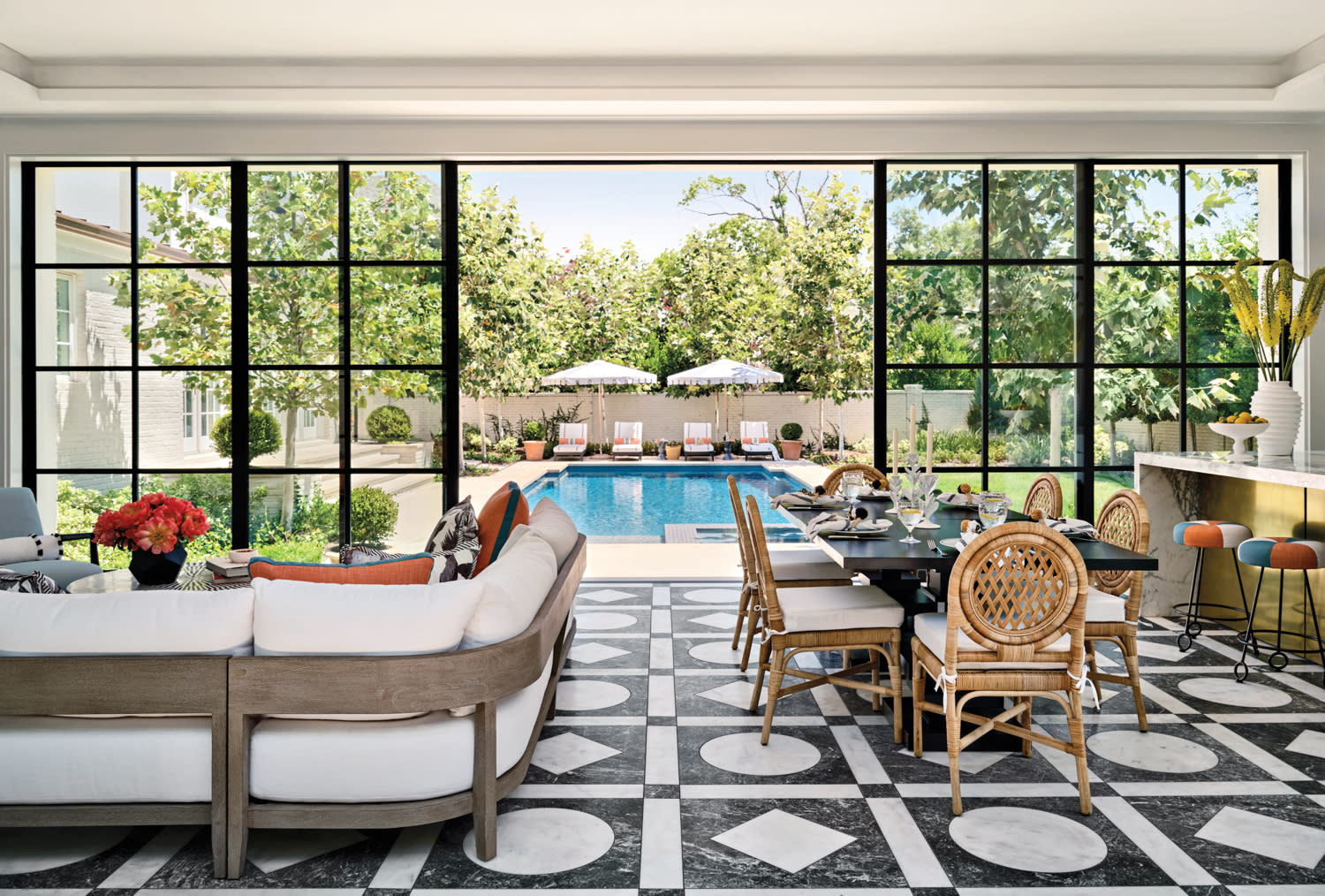 modern pool house with black and white geometric flooring and views of the backyard