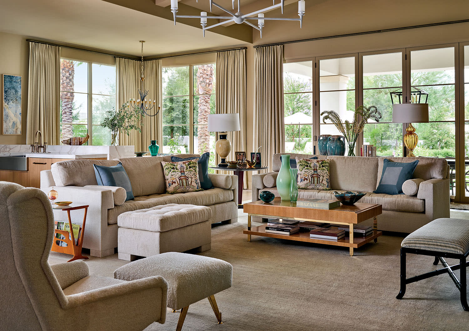 Bright and spacious living room with beige sofas, colorful vases, and pillows