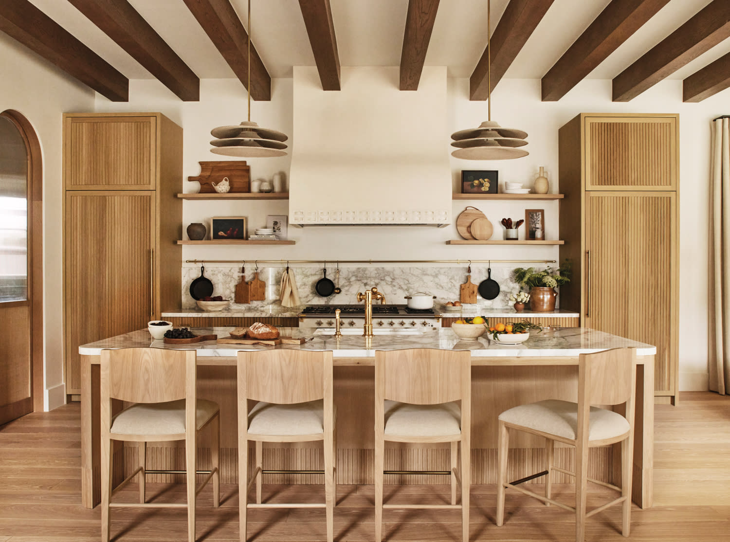 exposed beams run across the ceiling of a natural, organic style kitchen