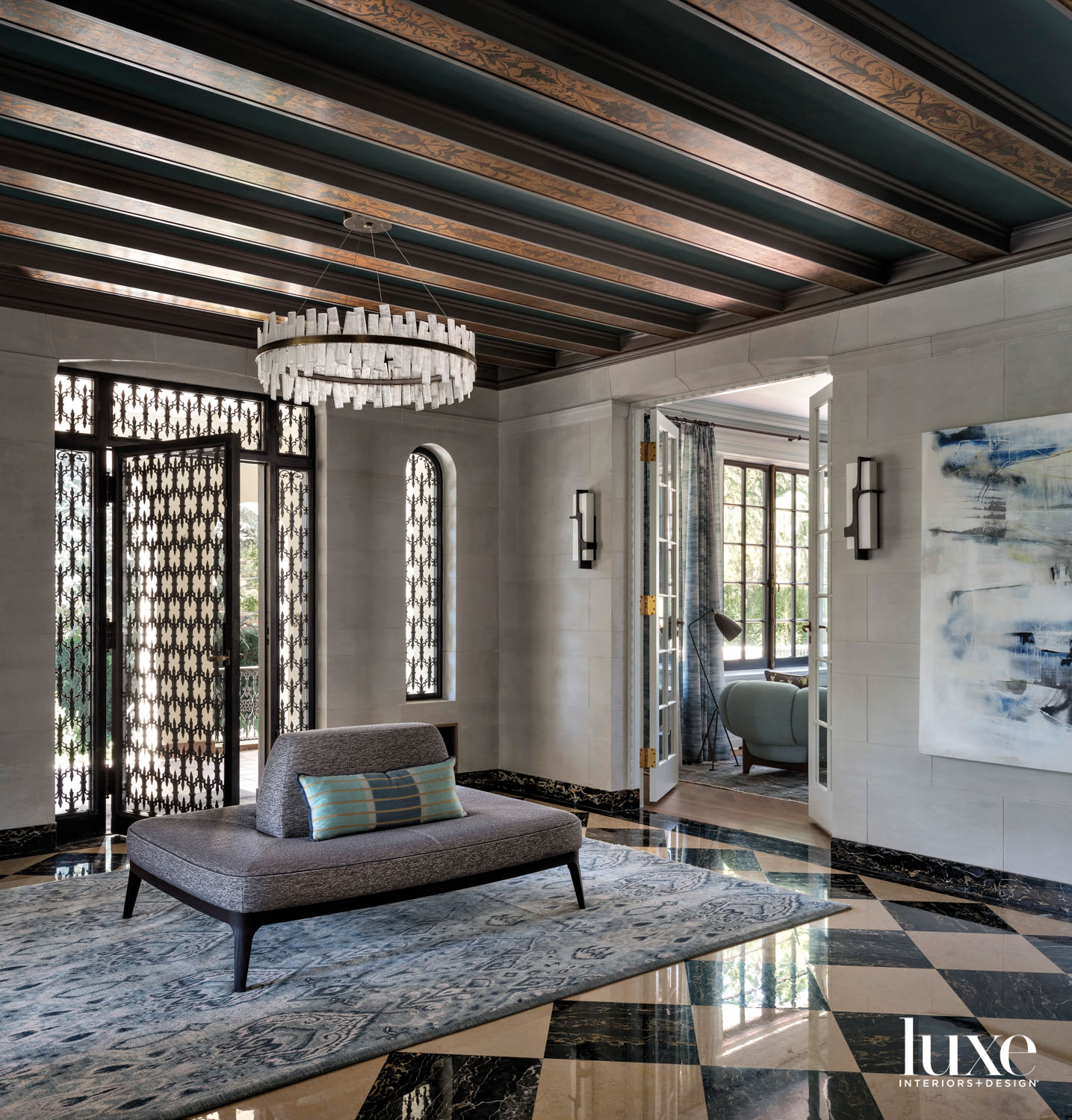Entry to home with black and white tile floor, sofa and round light fixture above