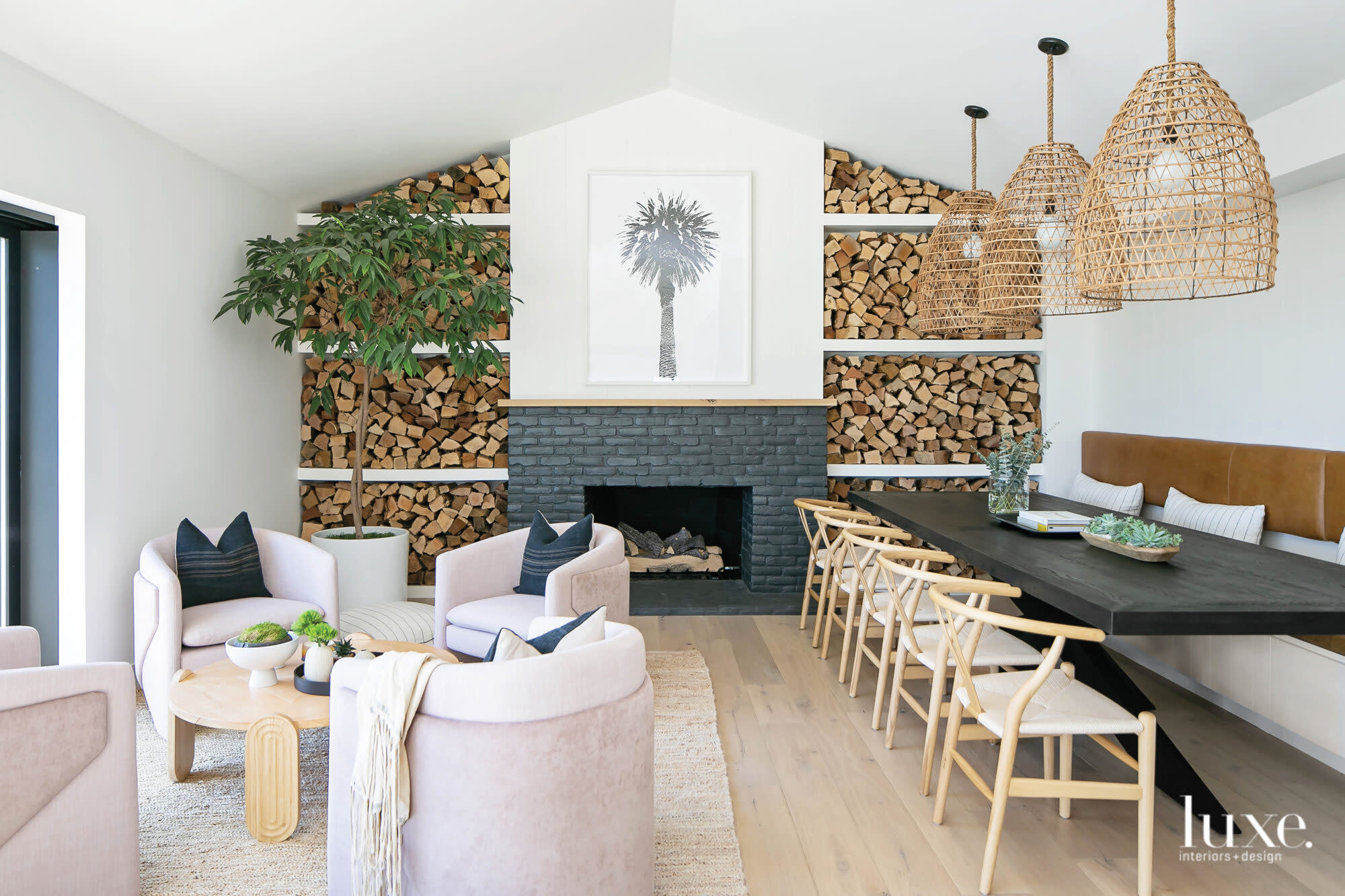 Dining room with seating area on one side and table and chairs on other with large fireplace flanked by wood accents