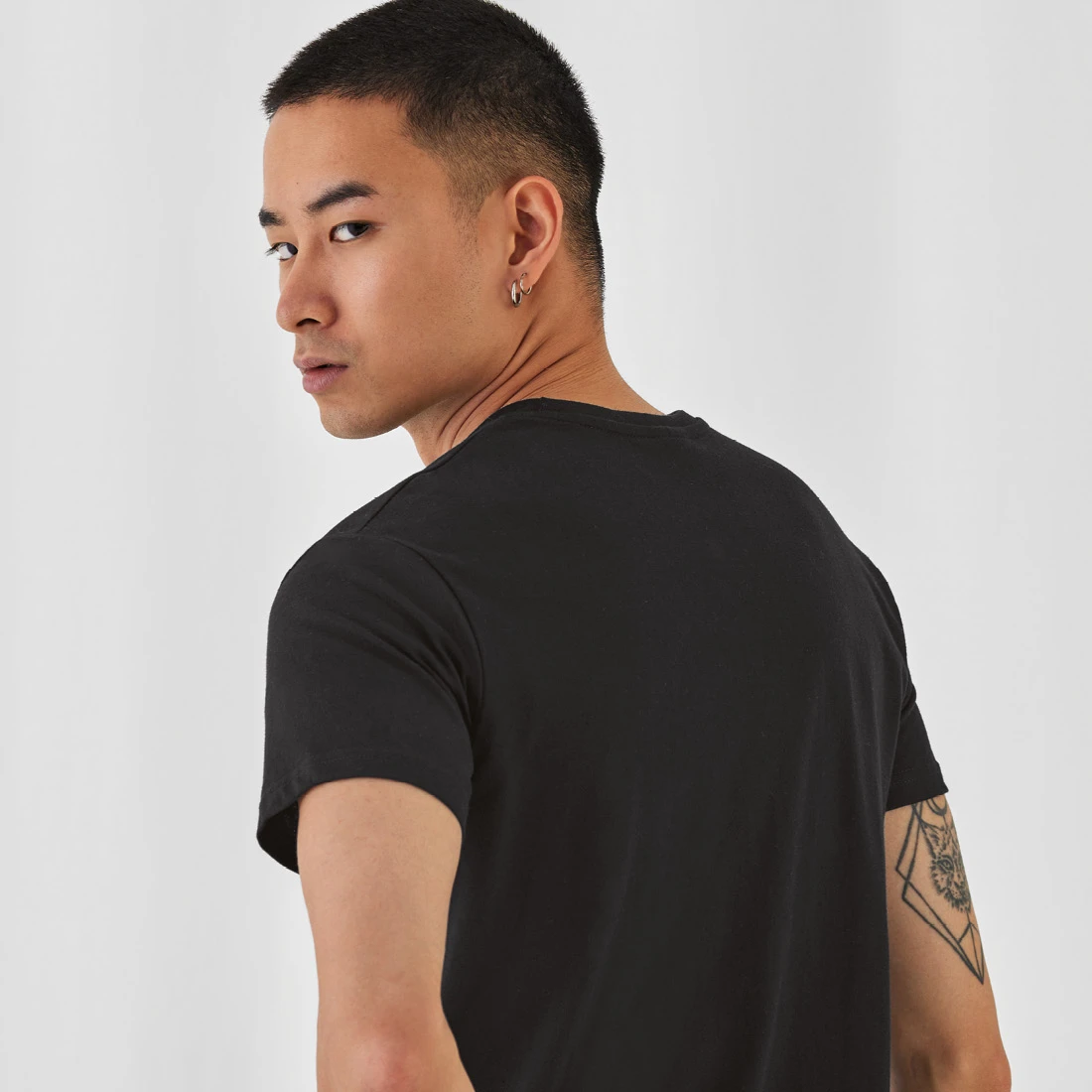 Close-up back view of man wearing black B&C E190 t-shirt